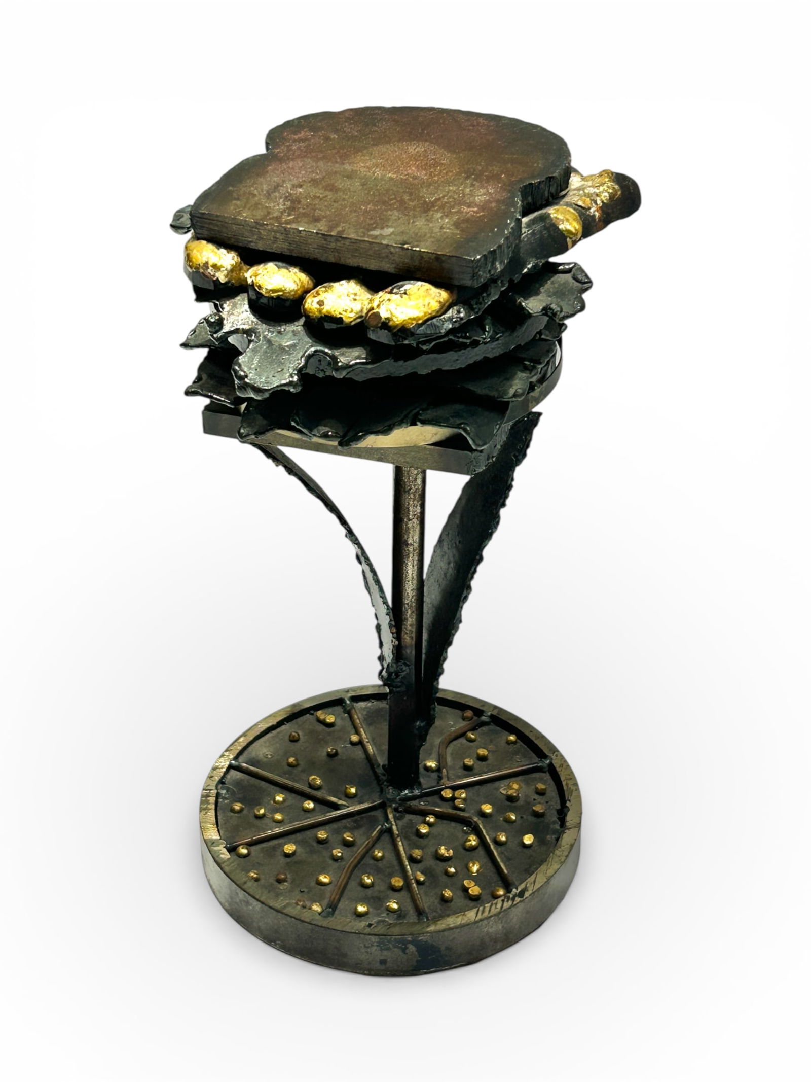 Brutalist / Surrealist Metal Sculpture of Sandwich: The surrealist brutalist brass, bronze, and metal sculpture depicts a thick sandwich in place of a flower, atop a stem with leaves. The sandwich appears to have hot dogs, tomato, bacon, onion, and