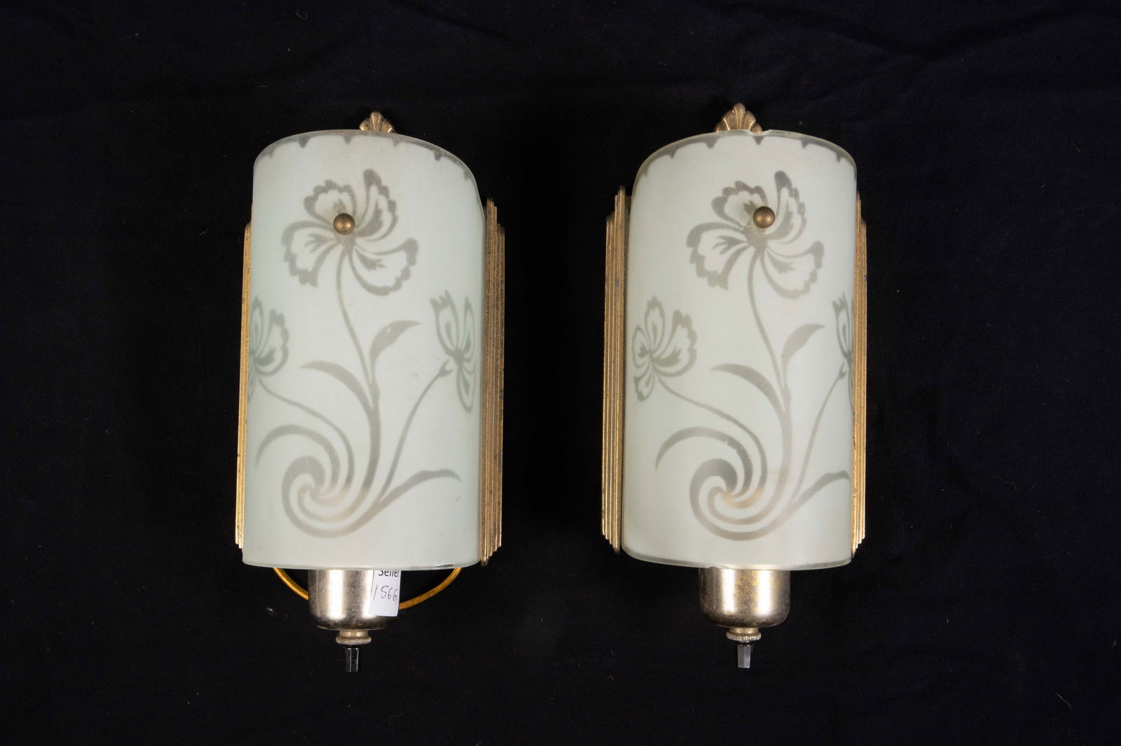 Pair of Art Deco Floral Swirl Frosted Wall Sconces: The pair of vintage glass and gilded metal wall sconces have frosted glass shades with a reverse etched triple flower / swirl design. They measure 10 1/4" x 4 7/8" x 3 1/2". One of the pieces has