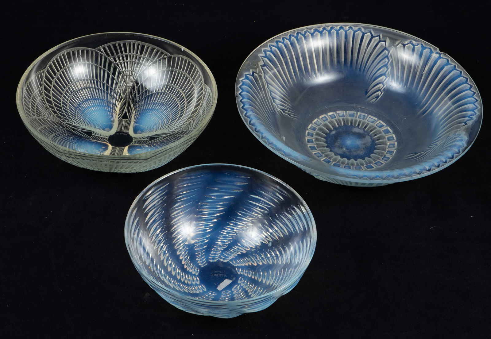 Lot of Three R. Lalique France Opalescent Bowls.: The largest bowl is As Is, with a noticeable chip and crack on the rim. The smallest bowl is in the Ondes design, with a chip on the exterior. The remaining bowl is in the Coquilles design, with some