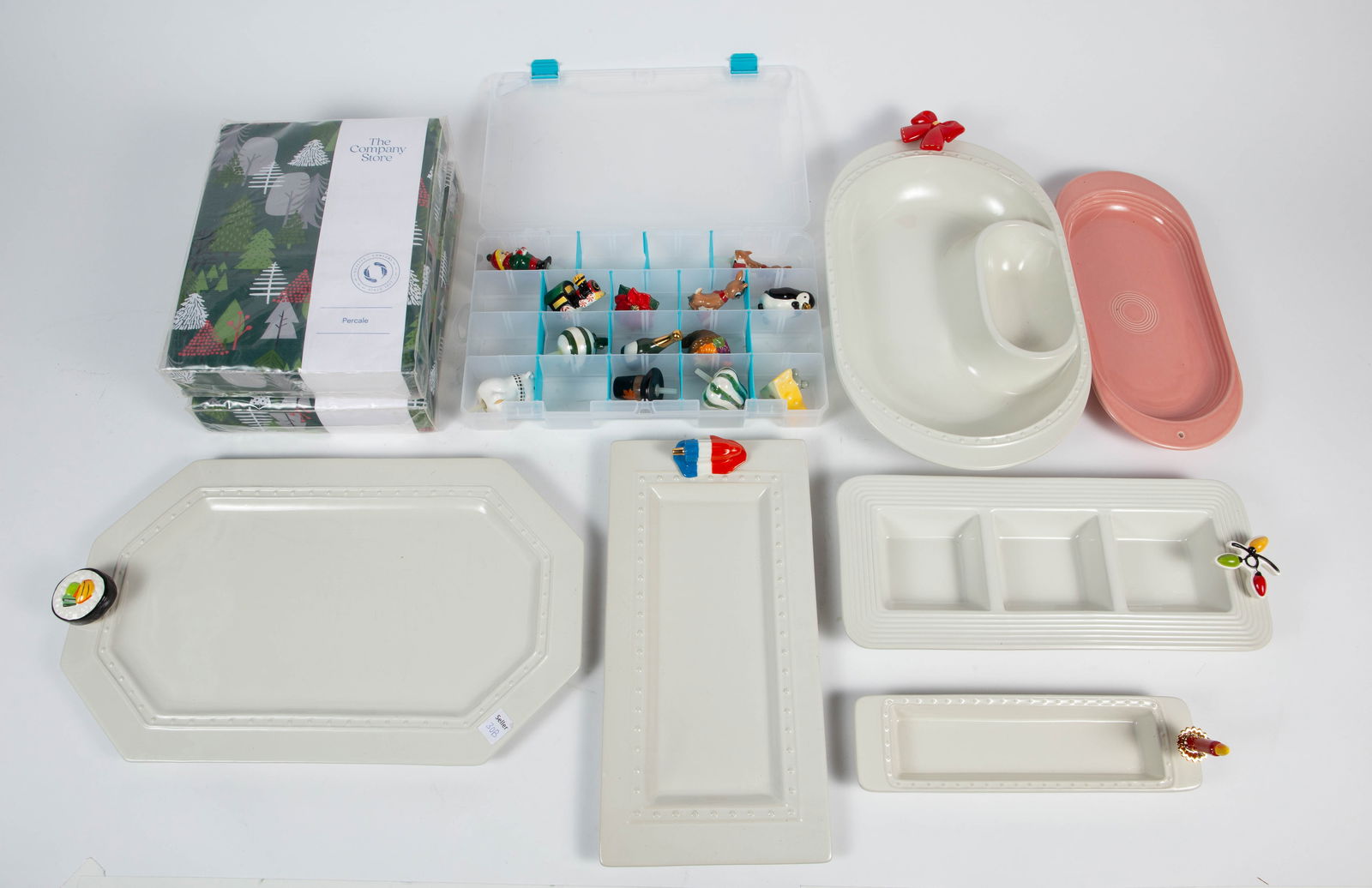 Lot of Nora Fleming Platters & Charms.: This lot includes several Nora Fleming dishes, including a pink Fiesta platter. It also comes with 18 Nora Fleming charms, mostly related to Christmas and other holidays. The poinsettia has a chip, bu