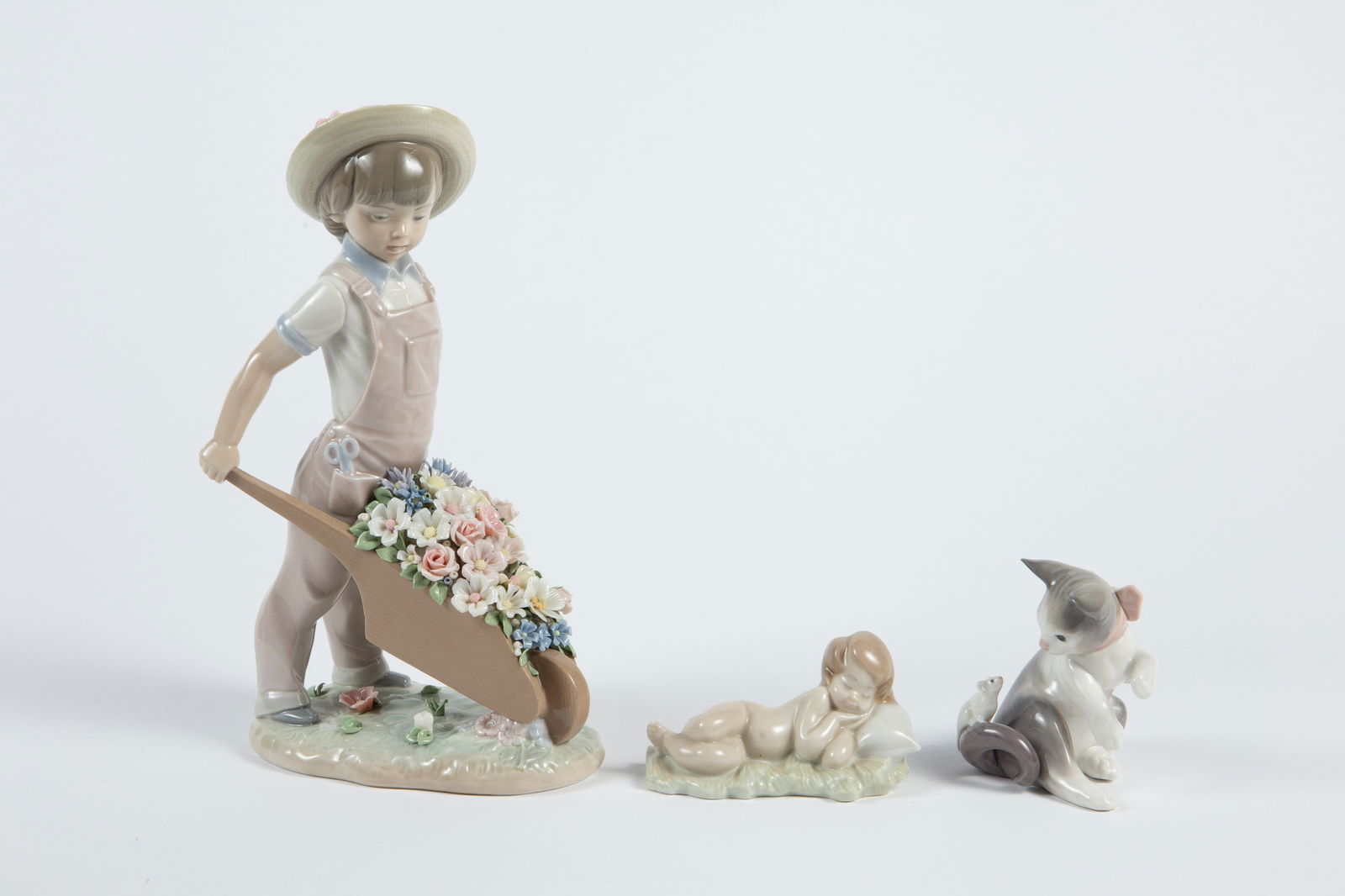 Lladro Lot of 3: Baby Jesus, Cat, Boy w/ Flowers.: This lot includes a sleeping Baby Jesus, a cat and mouse figurine, and a "Little Gardener" figurine. This last item has a few petals with minor damage, but overall, the lot looks to be in nice conditi