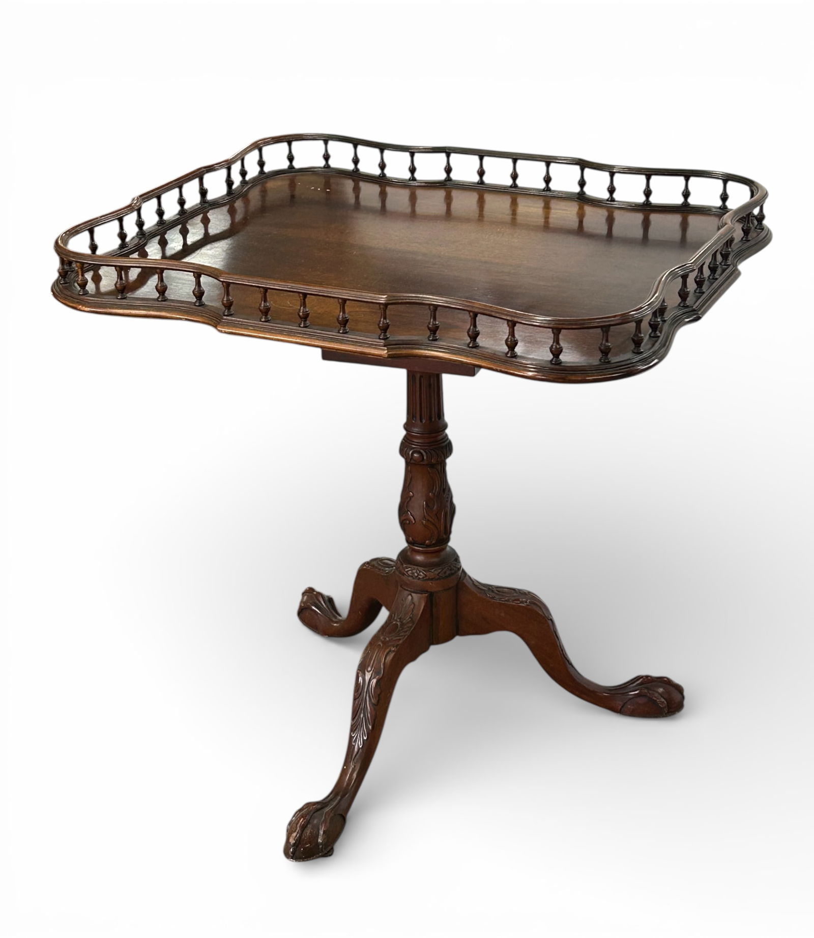 Mahogany Table with Gallery Top.: This Georgian style table has a spindle gallery top, carved tripod legs, and carved feet. There are a few minor scratches, but overall, it is in good condition. The piece measures 29" wide, 24" deep,