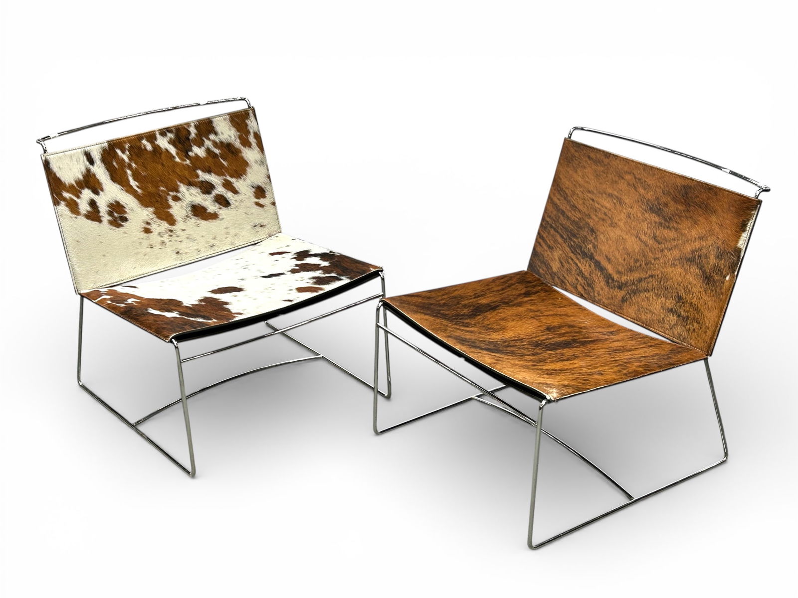 Pr of Pascal Mourge for Ligne Roset Cowhide Chairs: These unsigned chairs have chrome plated steel tubular frames with cowhide seats and backrests. There are minor scratches, but overall, the chairs are in nice condition. Each one measures 25 1/2"