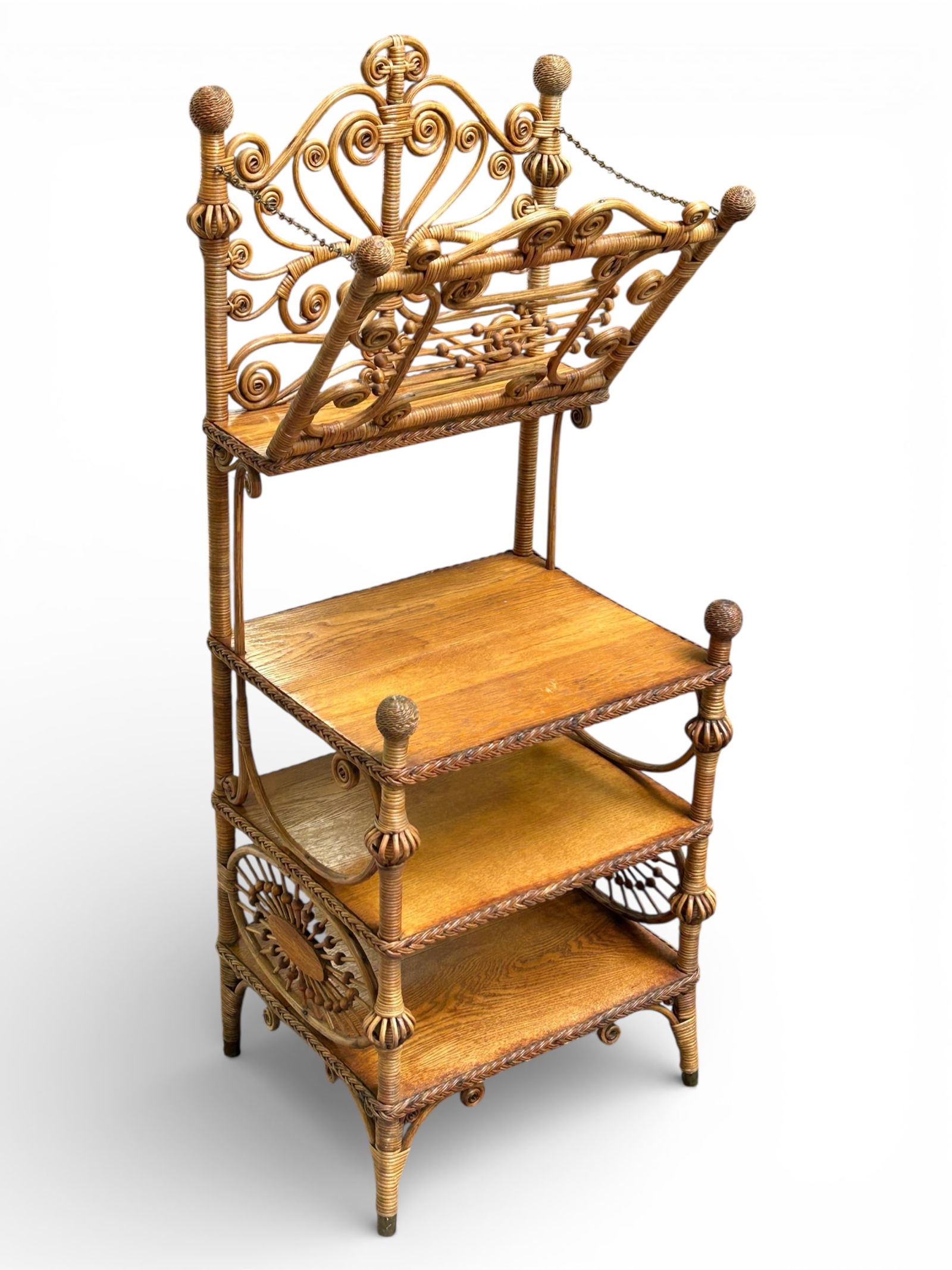 Victorian Wicker & Oak Magazine Rack / Etagere.: This piece has a top rack with a drop-down holder, three lower shelves, ornate wicker scrollwork, and a stick-and-ball design. There is some damage to one of the designs on the side of the piece.