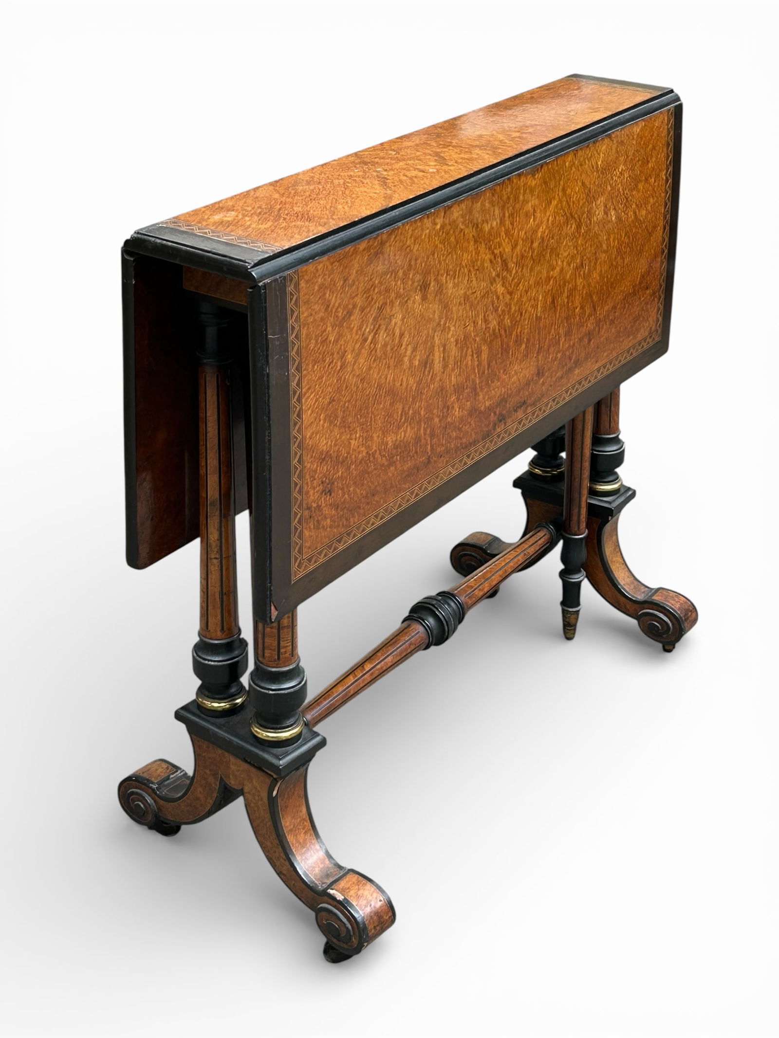 Antique Victorian Sutherland Table.: This small, fine ebonised and burled walnut table has a beautiful inlaid border. It features two drop leaves that are supported by gate legs. It has fluted supports and sits on scrolled feet with