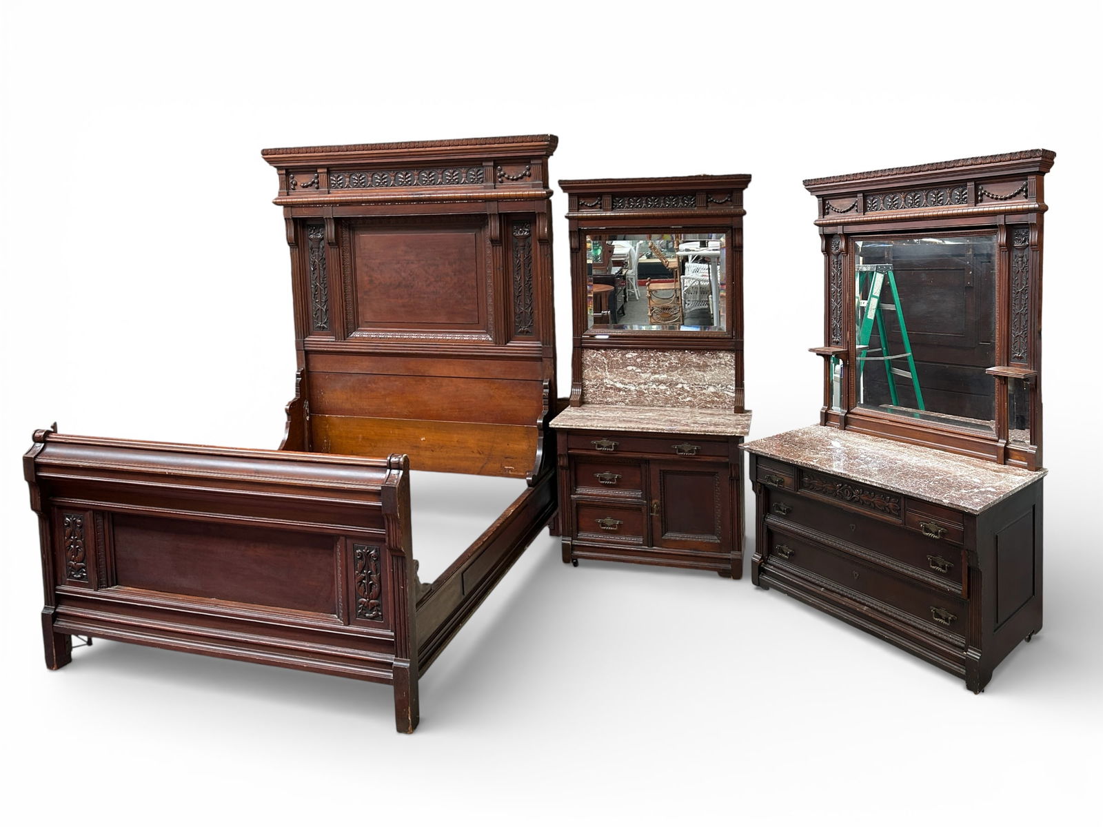 Ornately Carved Victorian Bedroom Set.: This outstanding walnut bedroom set consists of two dressers and a Queen bed. The first dresser has a bevelled mirror with candlestands on either side, and bevelled mirrors below. It has a large pink