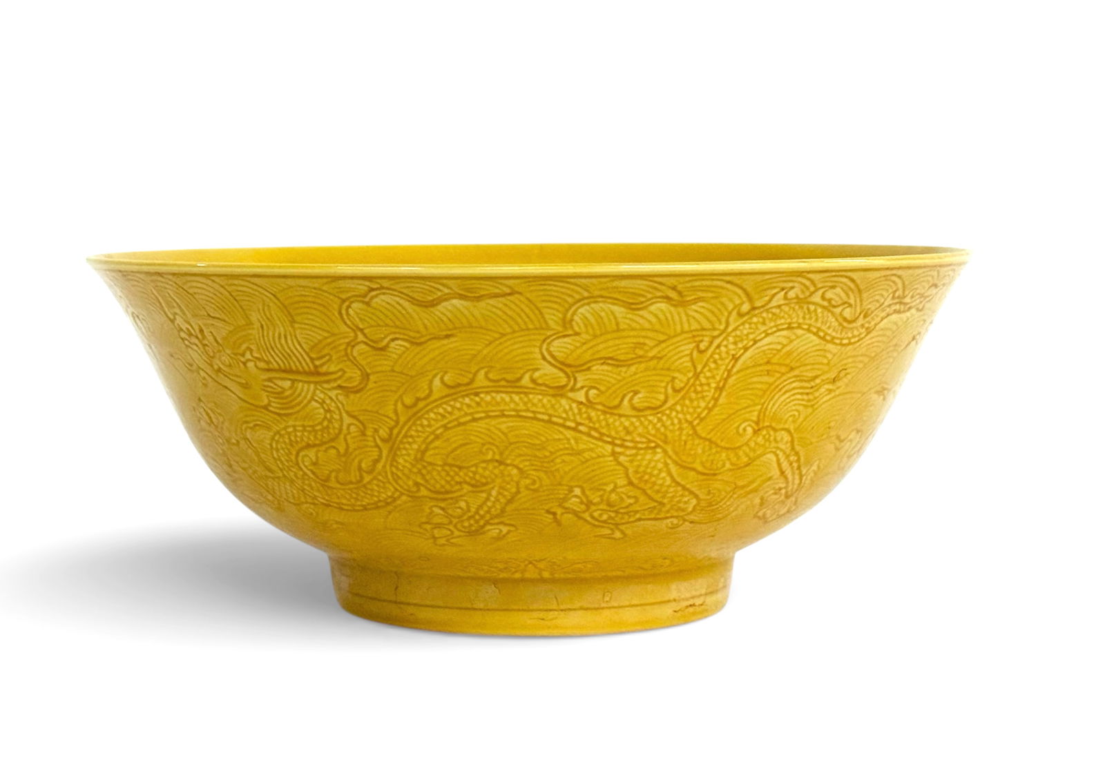 Large Chinese Yellow Glaze Bowl w/ Dragon.: The bowl has dragon designs on the outside and a dragon design on the interior of the bowl. It is signed on the underside. The bowl is in good overall condition. It measures 3" tall and 7 3/8" in diam