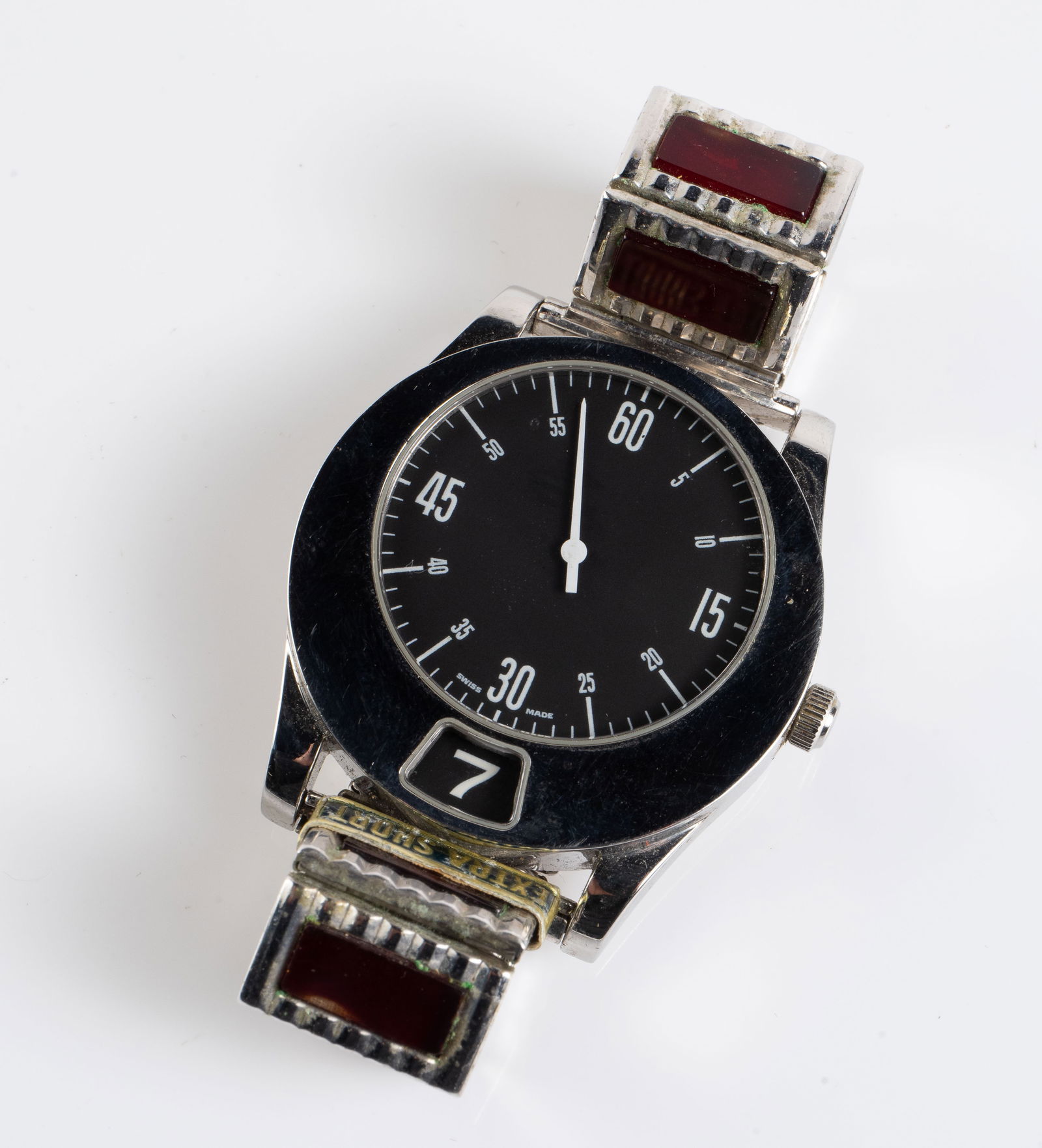 Gianni Bulgari Jump Hour Watch.: The vintage stainless steel jump hour watch has a black dial and a white minute hand. The band has 4 links with rectangular red stones on either side, and a partial Speidel stretch section. It still