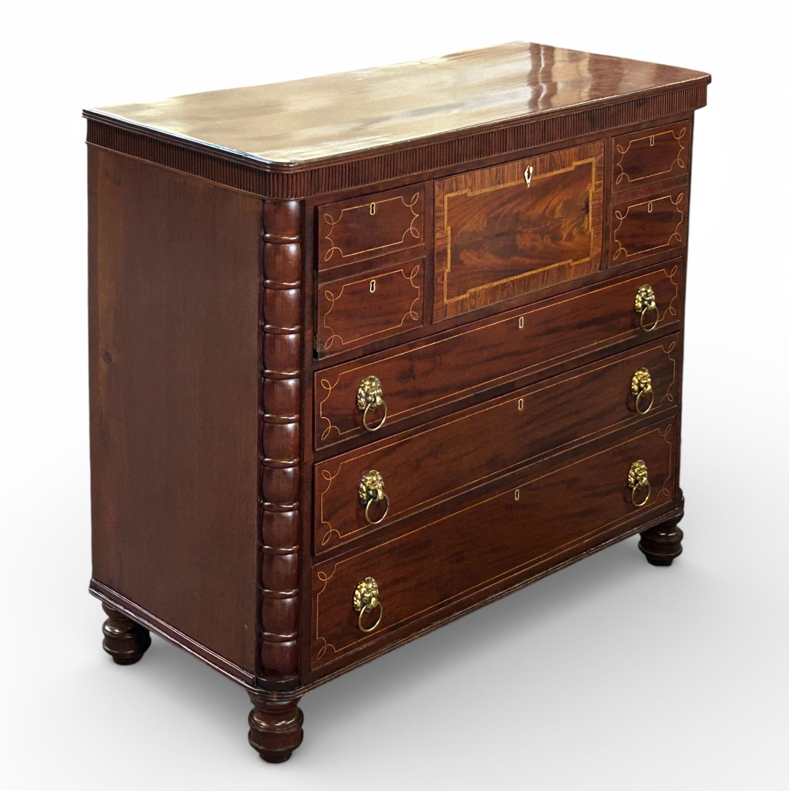 Antique Mahogany Butler's Desk.: This gorgeous desk has a fall front with a leather top, a small flamed and banded door, ten small drawers, and ten cubby holes. Below the desktop are three large drawers with lion head pulls and