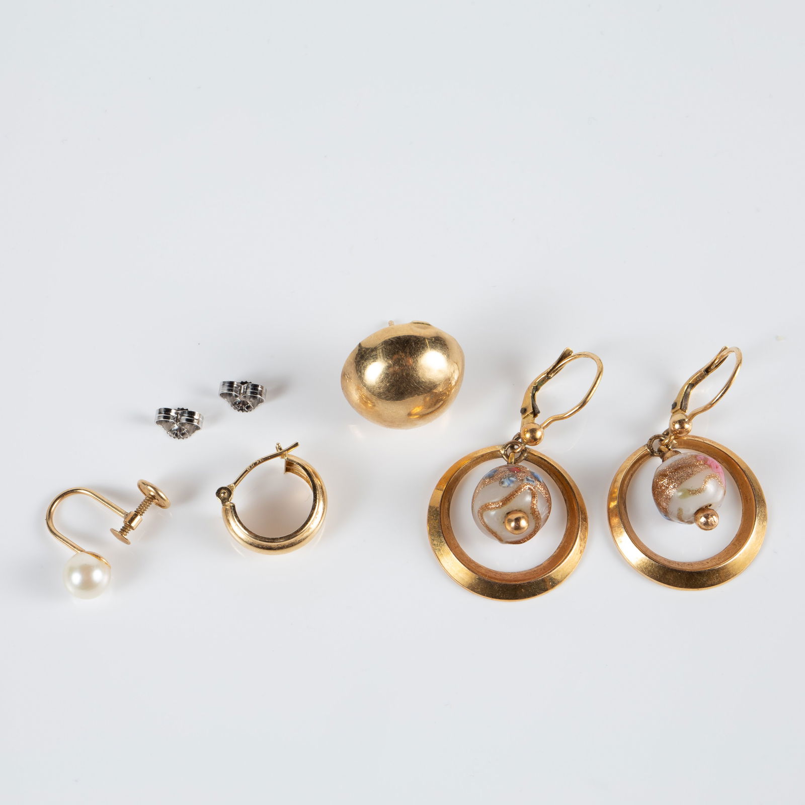 14K Gold Earrings & Group of 14K Scrap Gold.: The lot contains a pair of earrings, 3 single earrings, and 2 14K white gold earring backs. The pair of earrings is marked 18K, but tested for 14K gold. They feature an artist made glass bead and meas