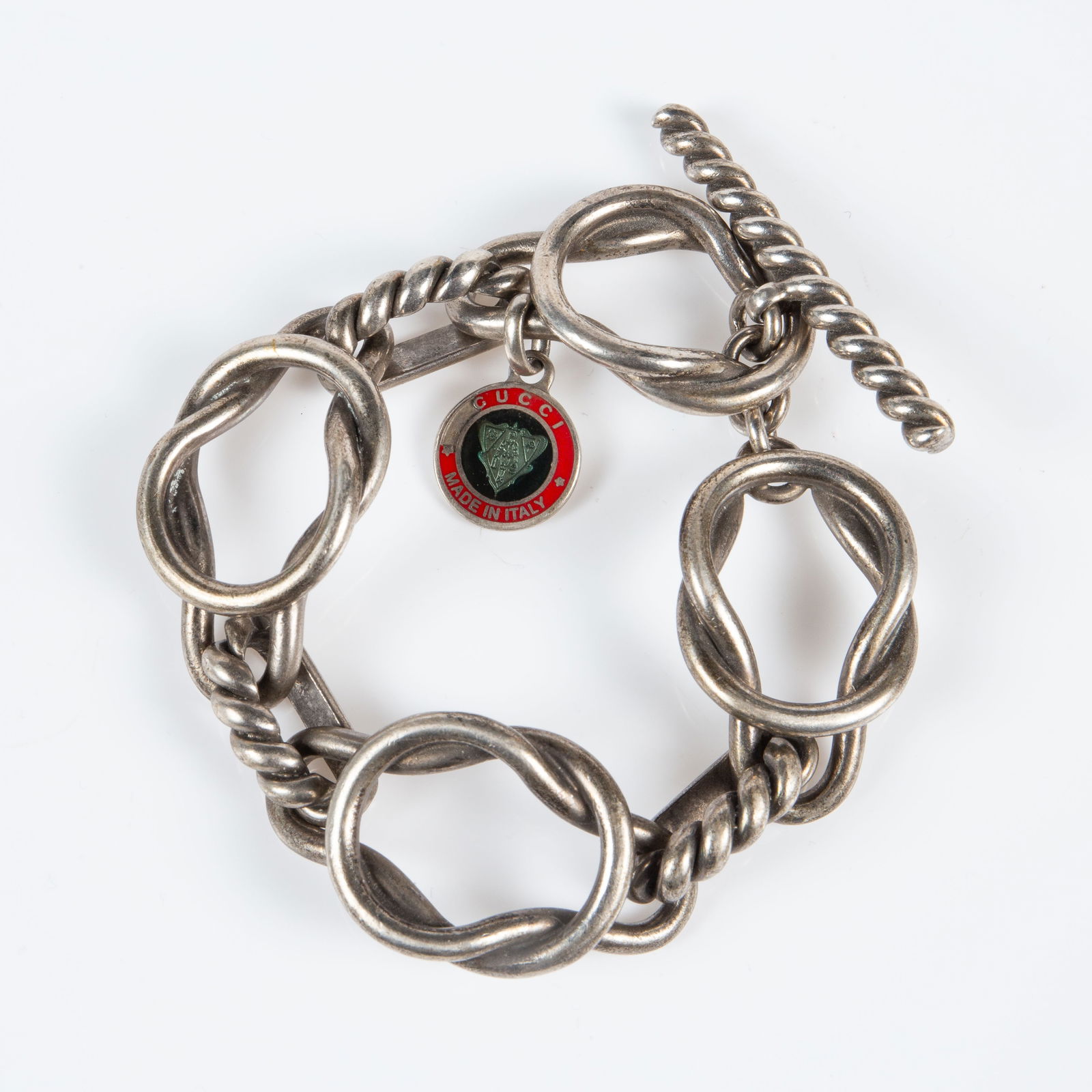 Vintage 925 Gucci Hercules Knot Bracelet.: The vintage sterling silver bracelet features 4 large Hercules knot links joined by 3 twisted pieces. The piece has a Gucci Made in Italy enamel charm, and one of the twist links is marked 20 / 603