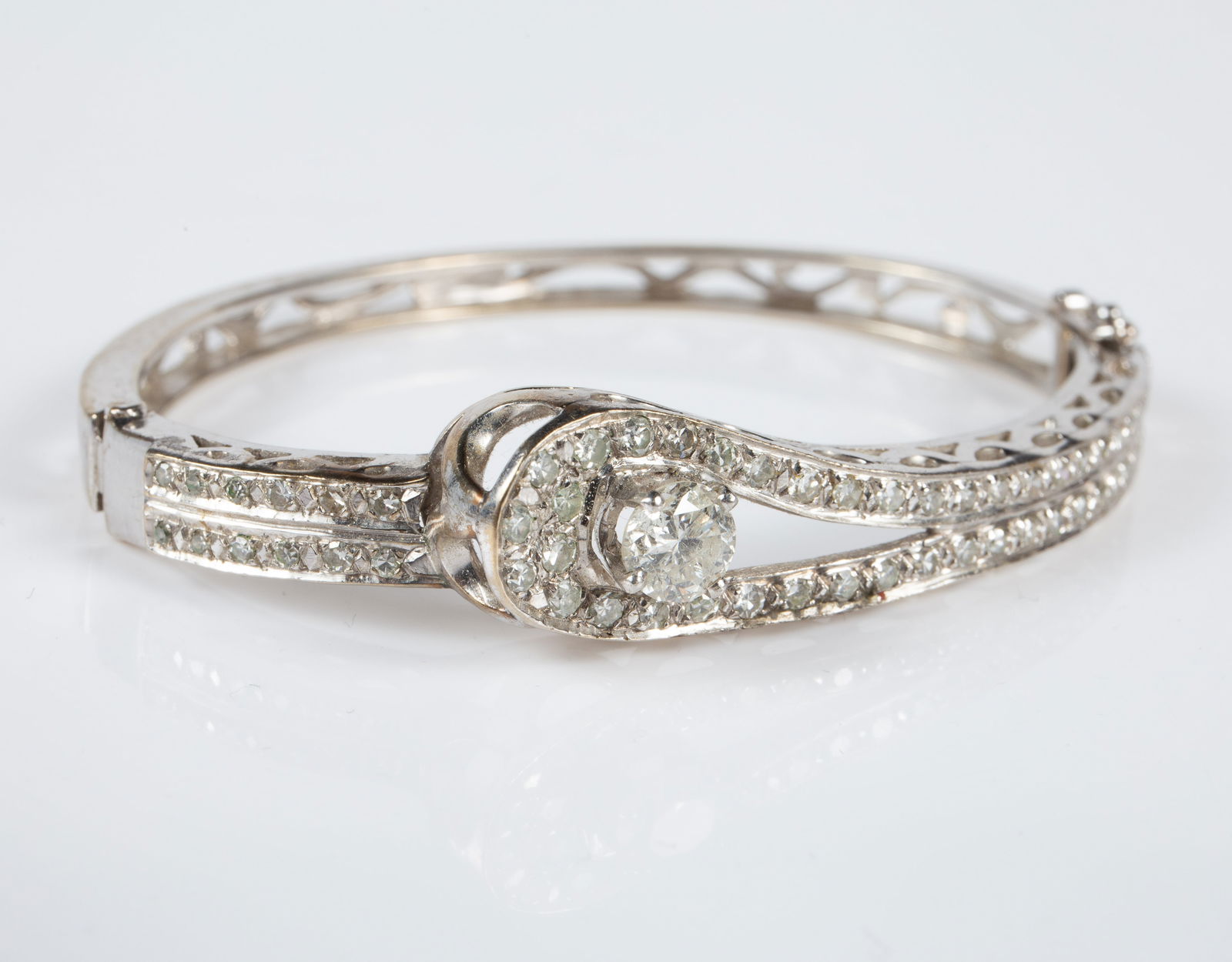 Vintage 14K White Gold & Diamond Bangle Bracelet.: The bracelet is marked S 14K on the clasp. It features many small round diamonds and a bigger diamond acting as a faux latch. The largest diamond measures 6mm in diameter which might possibly be