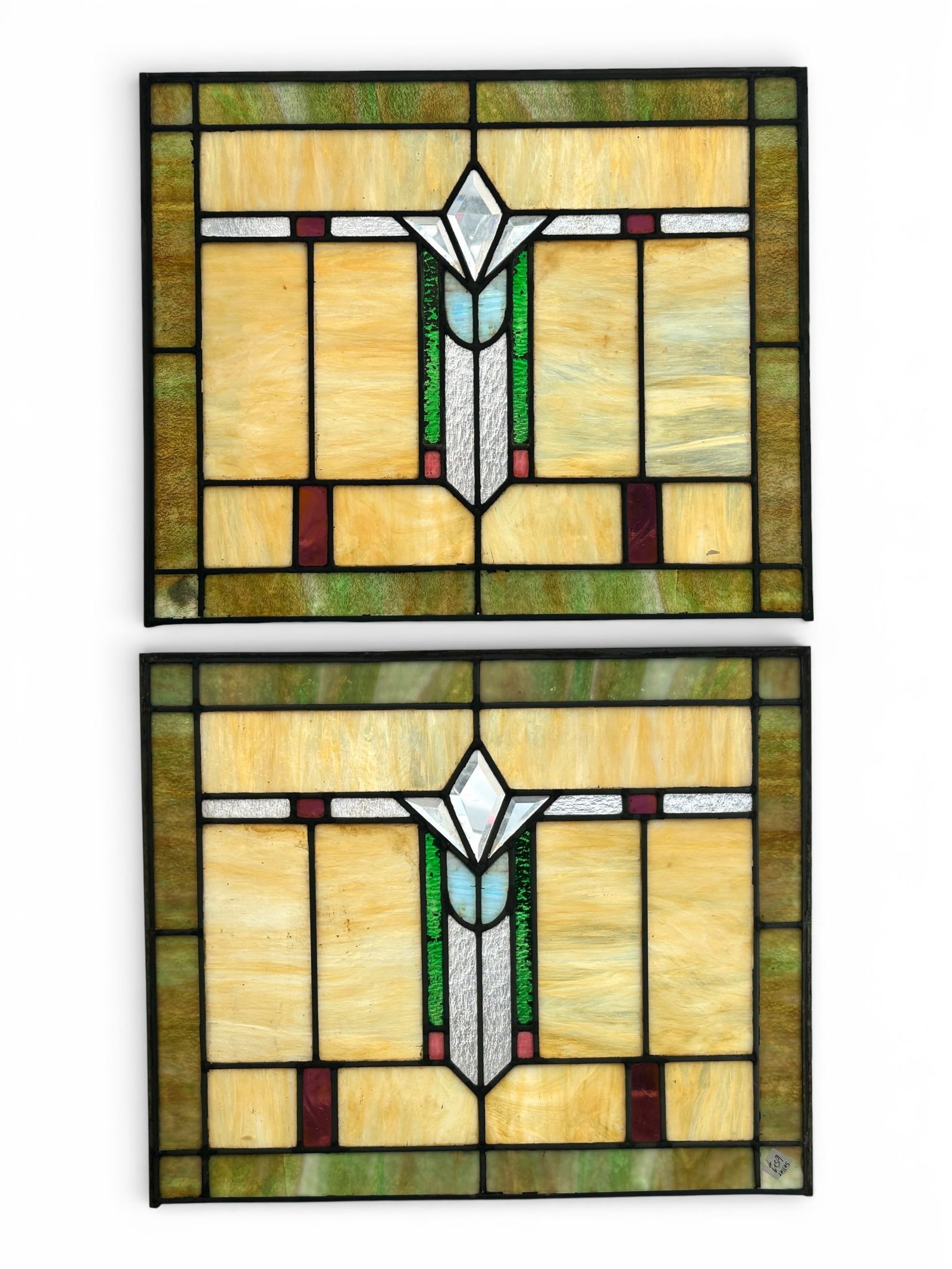 Pair of Prairie Style Slag Stained Glass Windows: The pair of windows feature slag, restoration, and bevelled glass panels in settings of the same metal as the frames. They measures 20 1/8" tall and 24" wide. There are some stains and scratches on