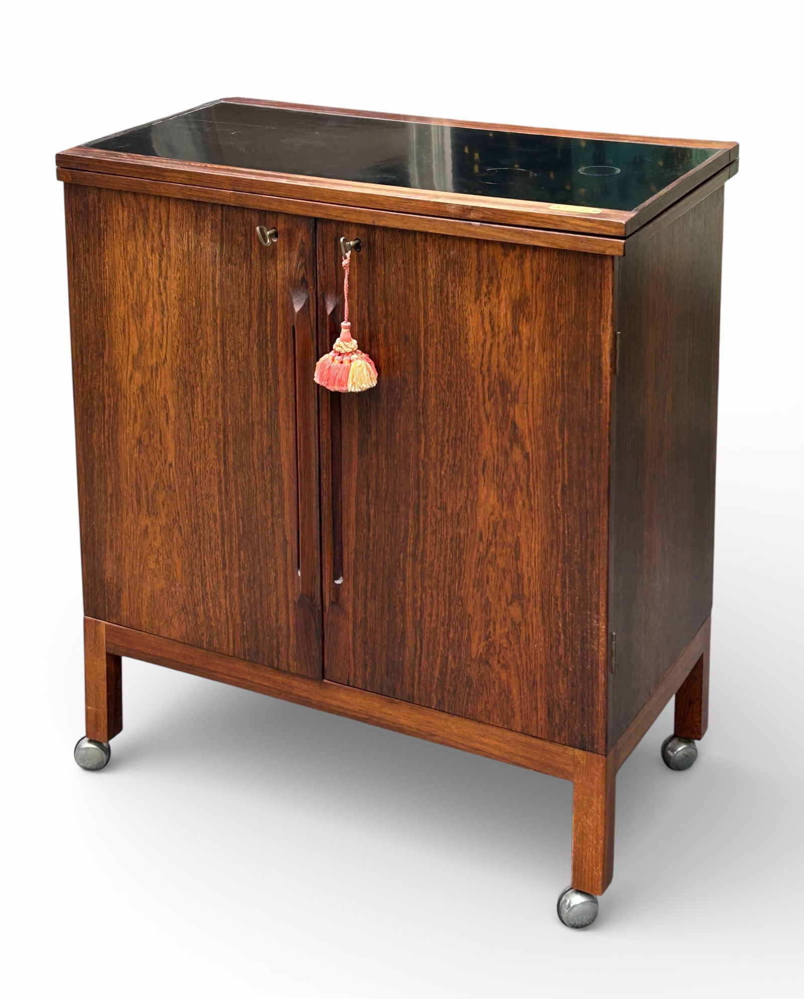 Torbjorn Afdal Rosewood Mid Century Bar Cabinet.: This Mid-Century Modern rolling bar cabinet has a label that reads, "A-S Mobelfabriken - Solid Gjovik - Bruksbo - Made in Norway." It features two locking doors with lots of storage for drinks and