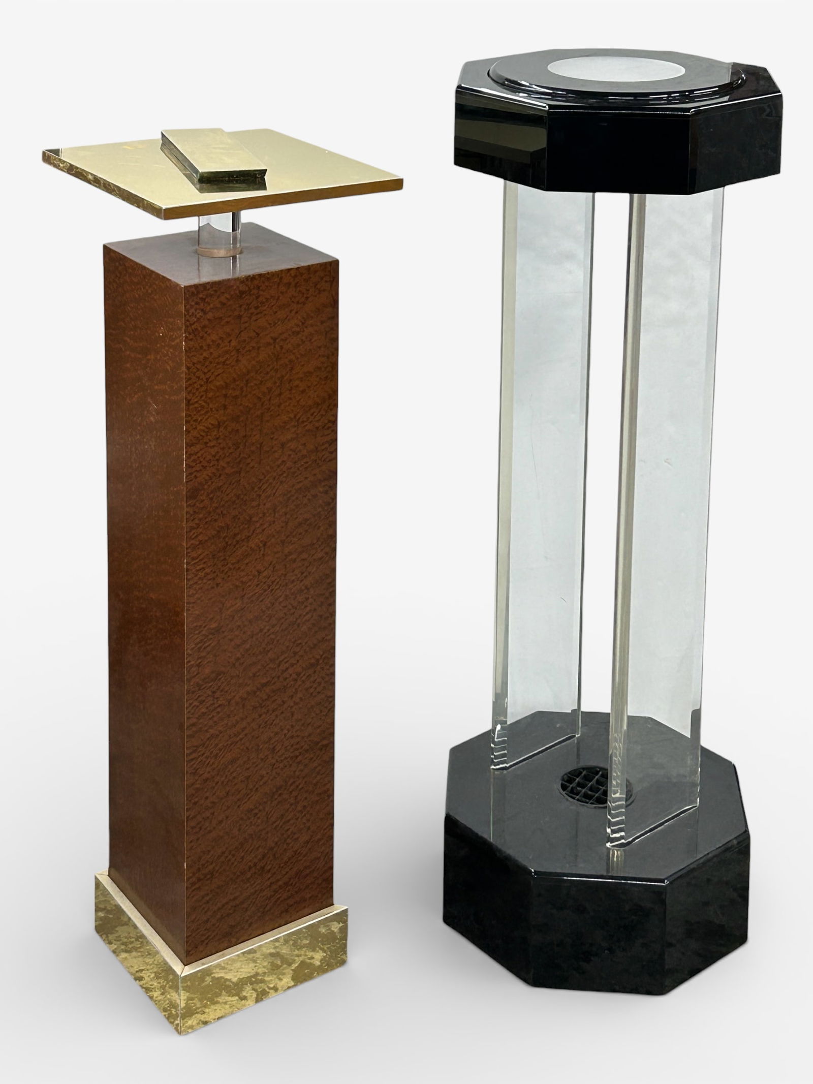 Two Pedestals - Lucite & Art Deco Style.: One pedestal has a black plastic top and base with lucite sides. The top has a small round glass insert. It rotates, and has an upper and lower light. It measures 15" wide, 15" deep, and 44" tall.