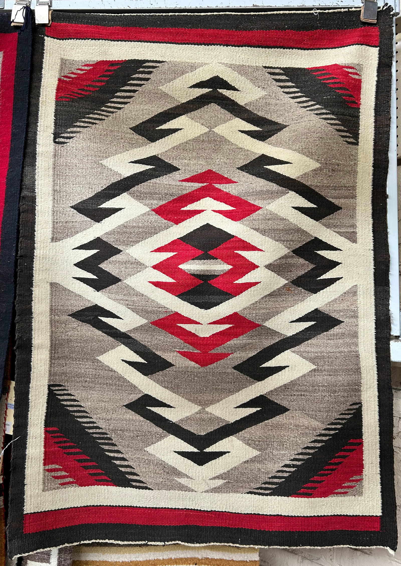 2' 10" x 4' 1" Vintage Navajo Eye Dazzler Rug.: The rug has some velcro attached to the back. The rug looks to be in good overall condition, with some wear to the edges. In-house shipping is available for this rug. Please see our website regarding
