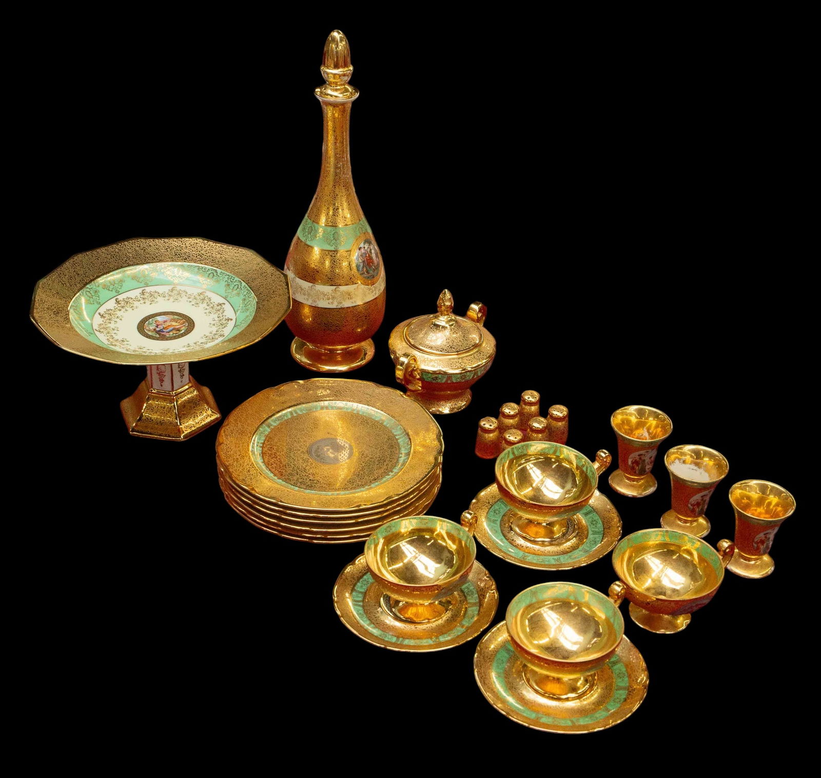 Lot of 24 Karat Gold Decorated Bohemian China.: Most of the pieces are made in Czechoslovakia. The lot includes a decanter with stopper, a compote bowl, a sugar bowl with lid, 6 salad plates, 6 salt shakers, 3 egg cups, 3 saucers, and 4 teacups.