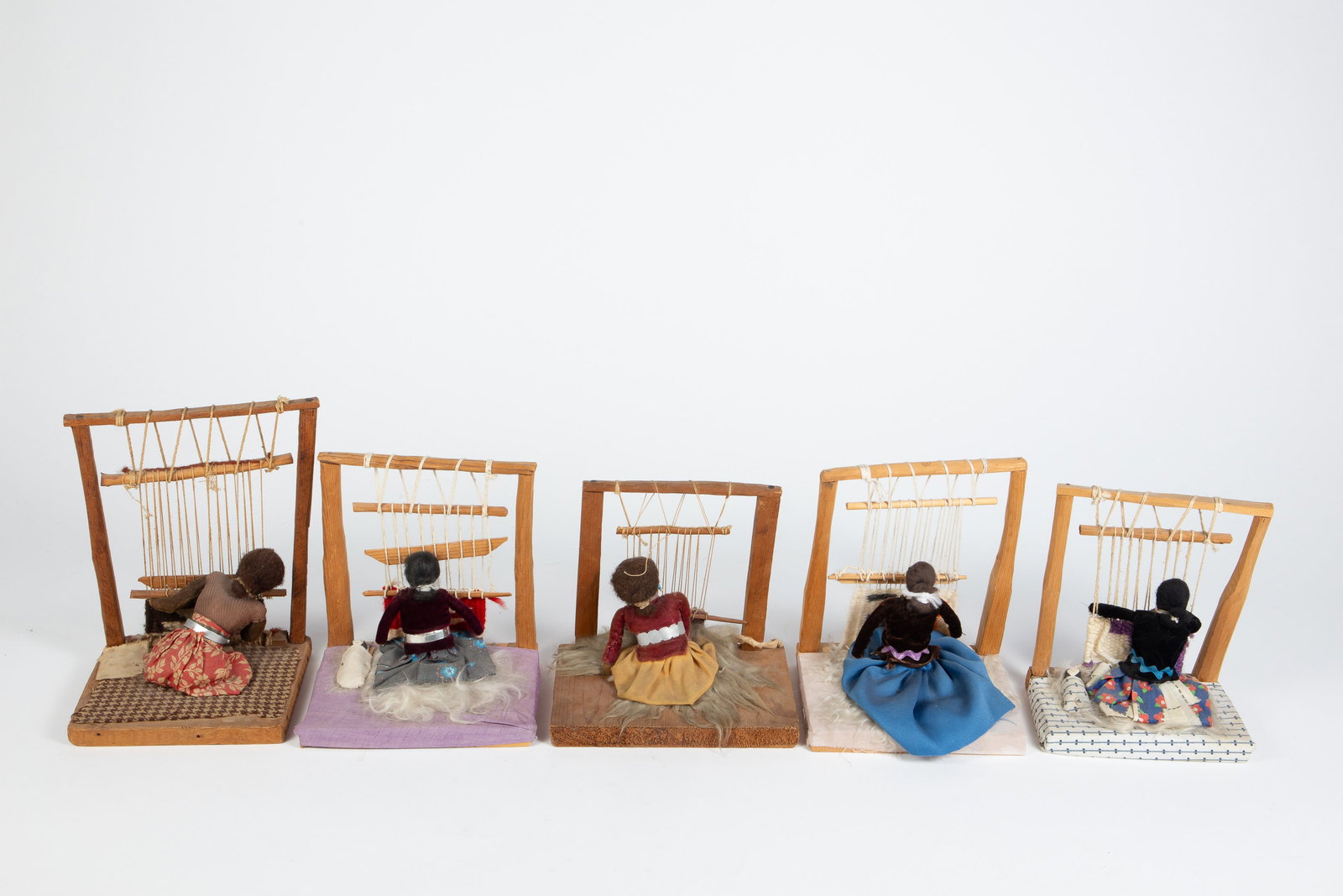 5 Navajo Figural Sculptures of Loom Weavers: The lot contains 5 Native American Navajo Indian sculptures of female loom weavers at work. The largest piece measures 9 1/2" tall, 7 7/8" wide, and 6" deep. One of the pieces has a "Made by American