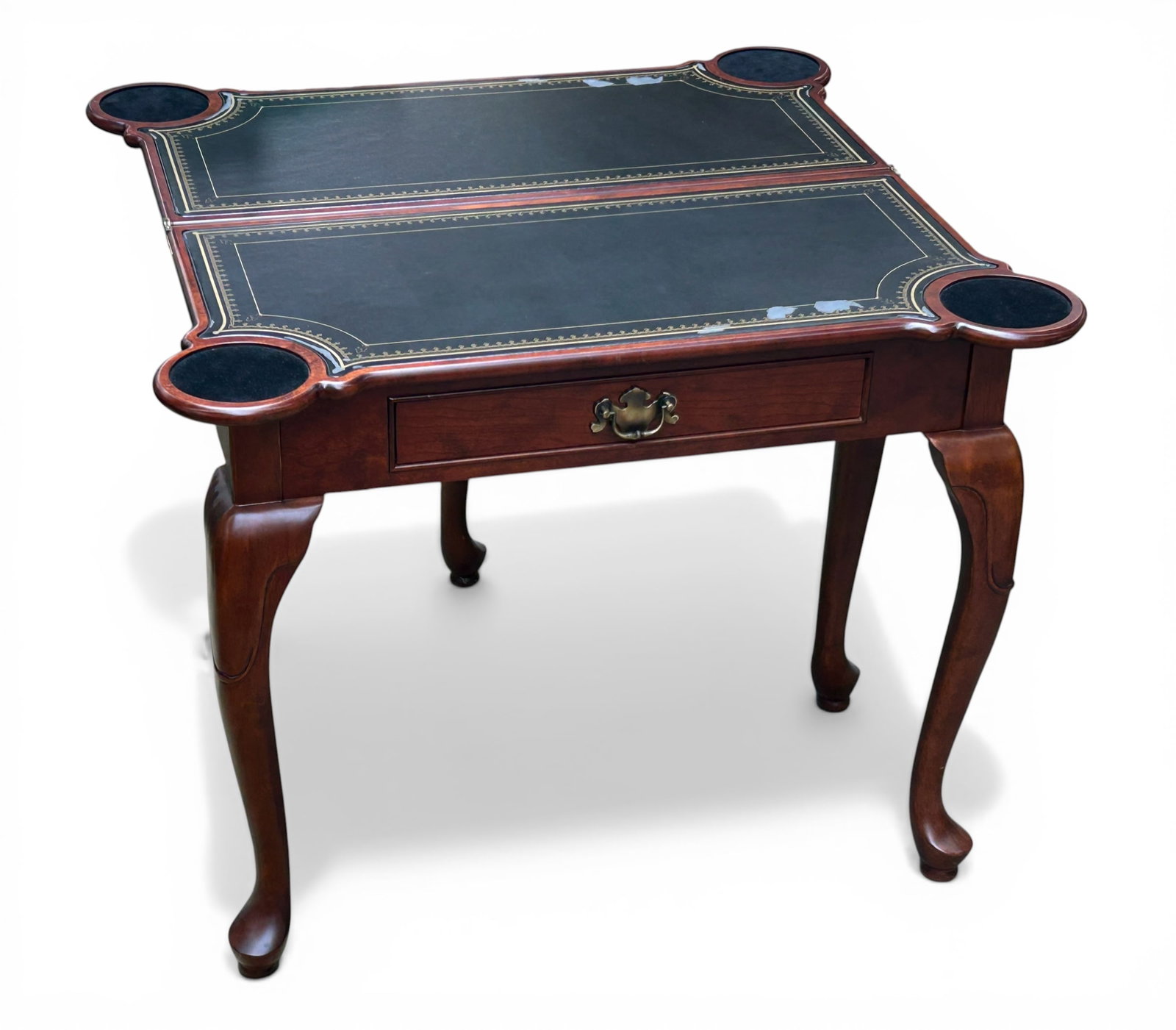 Contemporary Queen Anne Style Game Table.: The table has a single drawer with a brass pull. The top flips out and is supported by a gate leg. The top (once flipped) has a faux leather surface with four spots for drinks. Some of the faux
