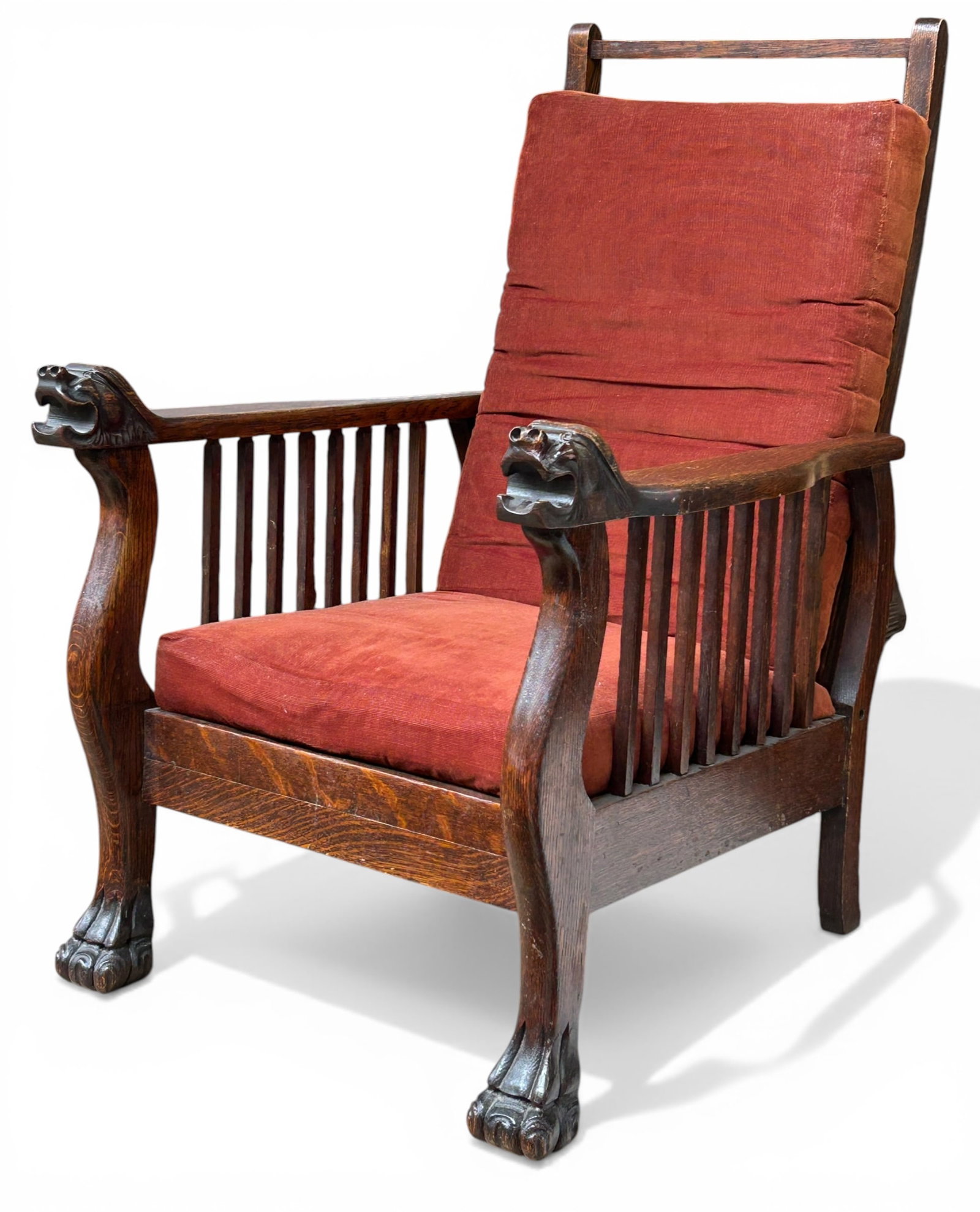 Antique Carved Oak Morris Chair.: This chair has carved lion heads, paw feet, slat sides, a reclining back, and removable brown cushions. The seat is pretty lumpy, and there are a few stains on the upholstery. Overall, it is in good c