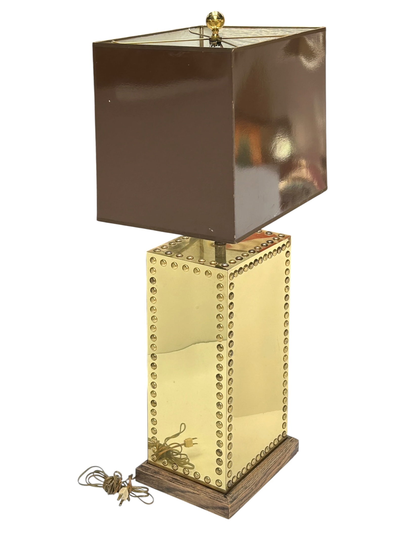 Vintage Table Lamp.: The lamp has a nailhead design with a wood base and a large rectangular shade. It is working, and in good cosmetic condition. It measures 38" tall. The shade measures 16" wide and 12" deep.