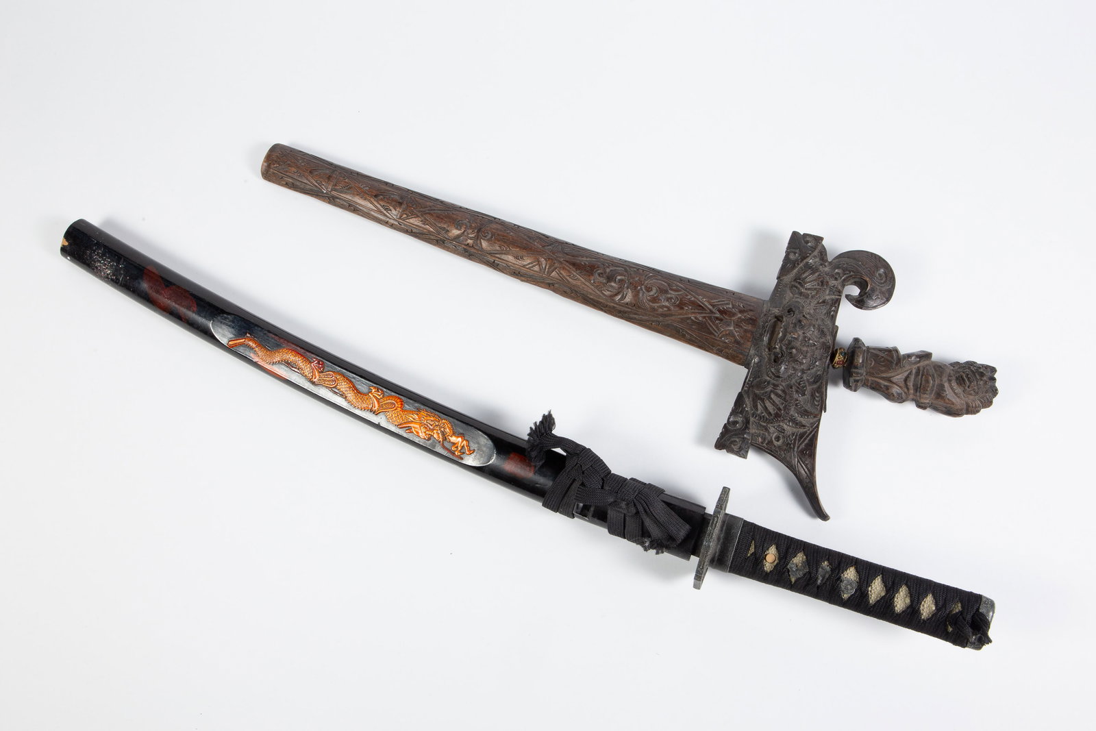 Lot of 2 Daggers: Indonesian Keris, Samurai Tanto.: The keris dagger measures 16 1/2" long, with a 12" wavy hand decorated blade. With the carved sheath, it measures 22 1/4" x 8" x 1 1/2". The newer samurai tanto measures 25 5/8", with an 18 5/8"