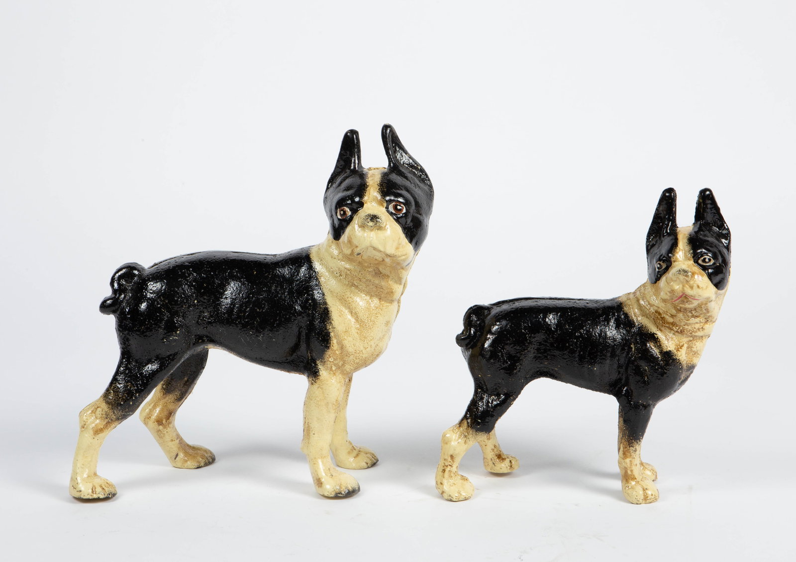 Lot of 2 Cast Iron Boston Terrier Doorstops.: There are some signs of paint loss and general surface wear. The larger dog measures 9 1/8" x 4 5/8" x 9 3/4". The smaller dog measures 6 7/8" x 3 1/2" x 8 1/8". In-house shipping is available. Please