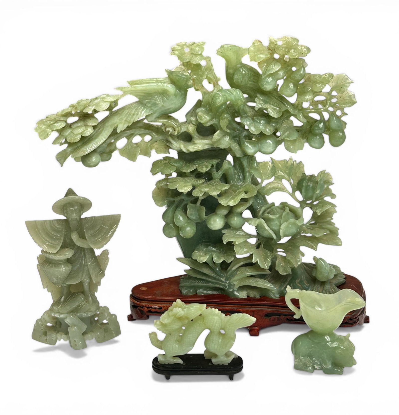 5 Chinese Carved Jade or Serpentine Sculptures.: The lot contains 3 small and 2 large carved jade sculptures. The largest piece, which is on a wooden stand, features flowers and fruit. The next largest piece depicts a pair of birds among foliage, an
