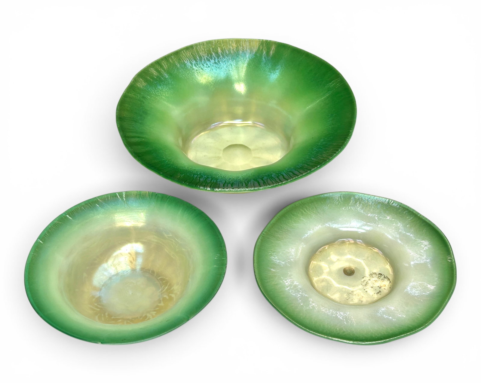 L.C.T. Tiffany Favrile Green Pastel Lot: 3 Dishes.: This lot includes a larger bowl with a flared rim (signed, "L.C.Tiffany - Favrile"), a smaller footed bowl (signed, 'L.C.Tiffany - Inc. Favrile"), and a saucer (signed, "L.C.T. Favrile", with an early