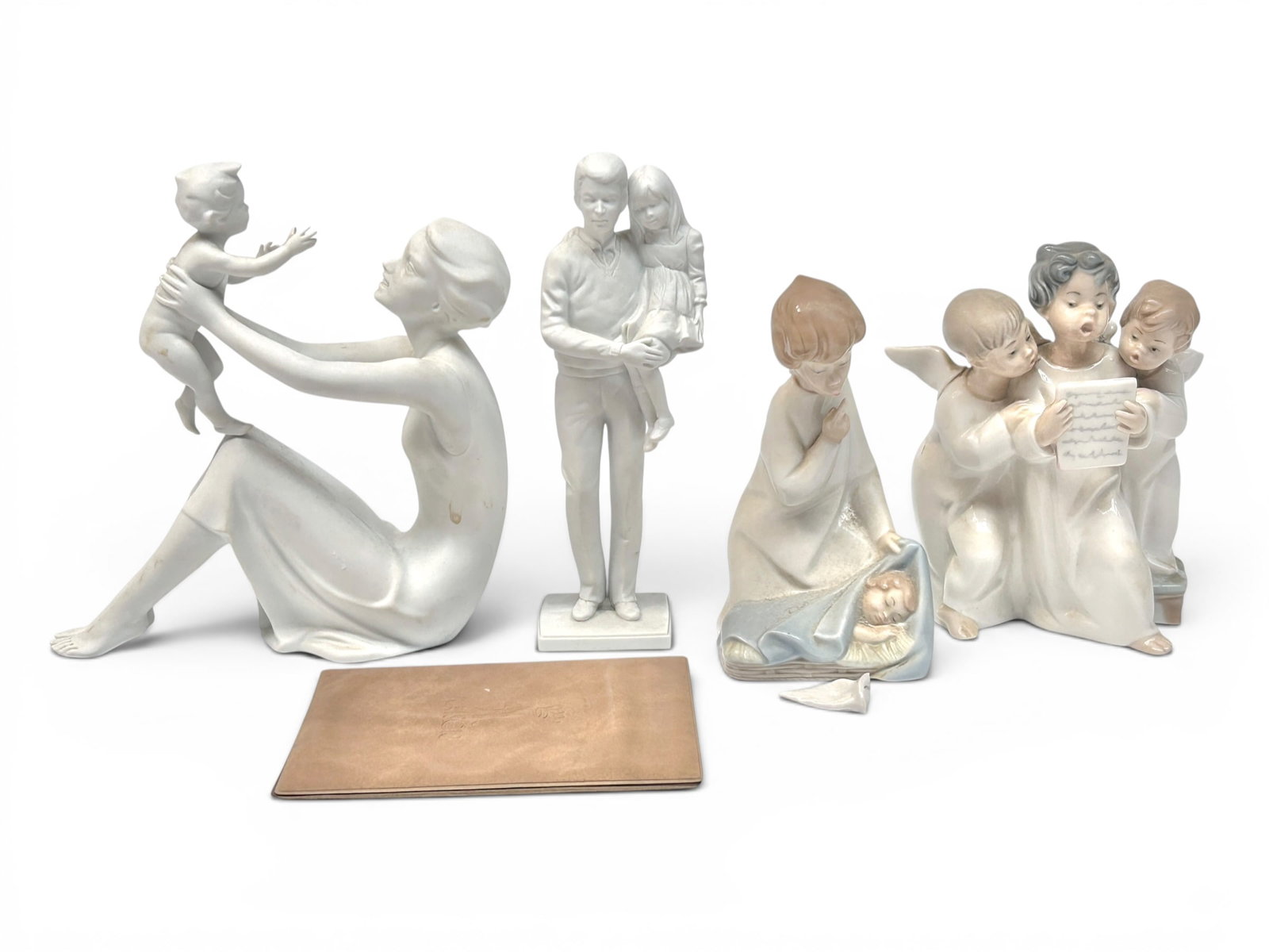 Lot of 4 Figurines- Lladro, Kaiser.: The Kaiser bisque figurines are a mother with child, and a father with daughter. They look to be in good condition. The Lladro angel figurines are as is, with broken wings. The largest figure in the l