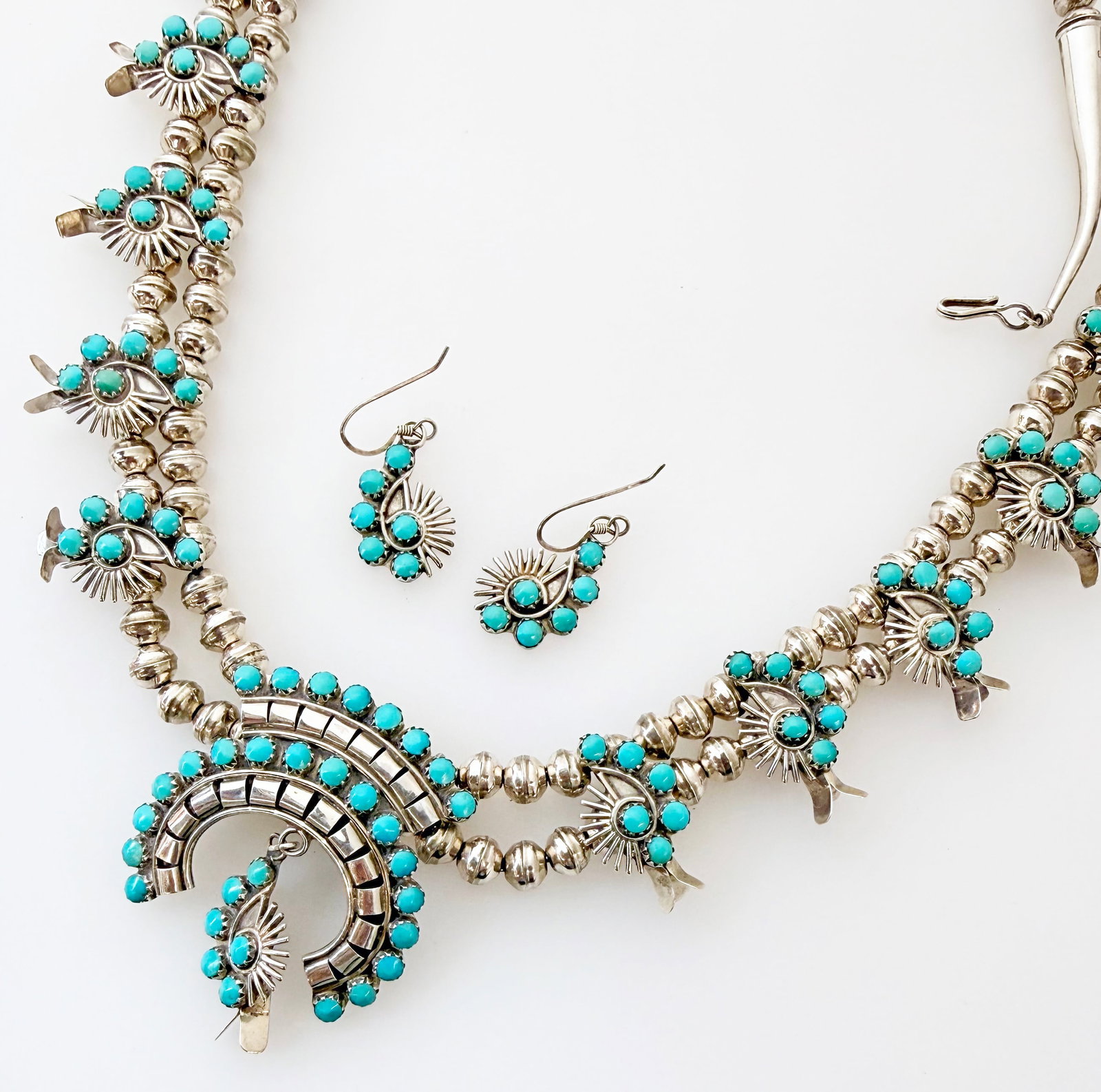 Southwest Squash Blossom Naja Necklace & Earrings.: The necklace is marked Sterling on the ends. It features a double strand of sterling silver beads with 12 squash blossoms, and a central Naja pendant with a dangle blossom. The piece is adorned with t