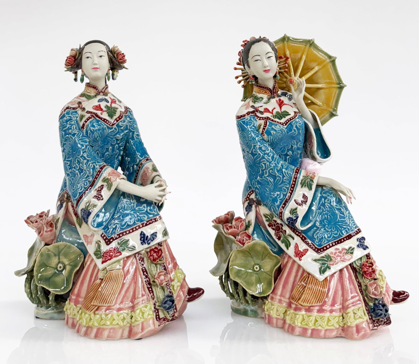 Lin Weidong Matched Pair Chinese Porcelain Figures: One of the women has a crack and some damage on her cuff. Otherwise, they are in good overall condition. These both measure approximately 10" tall, 6 5/8" wide, and 4" deep. Third-party shipping or pe