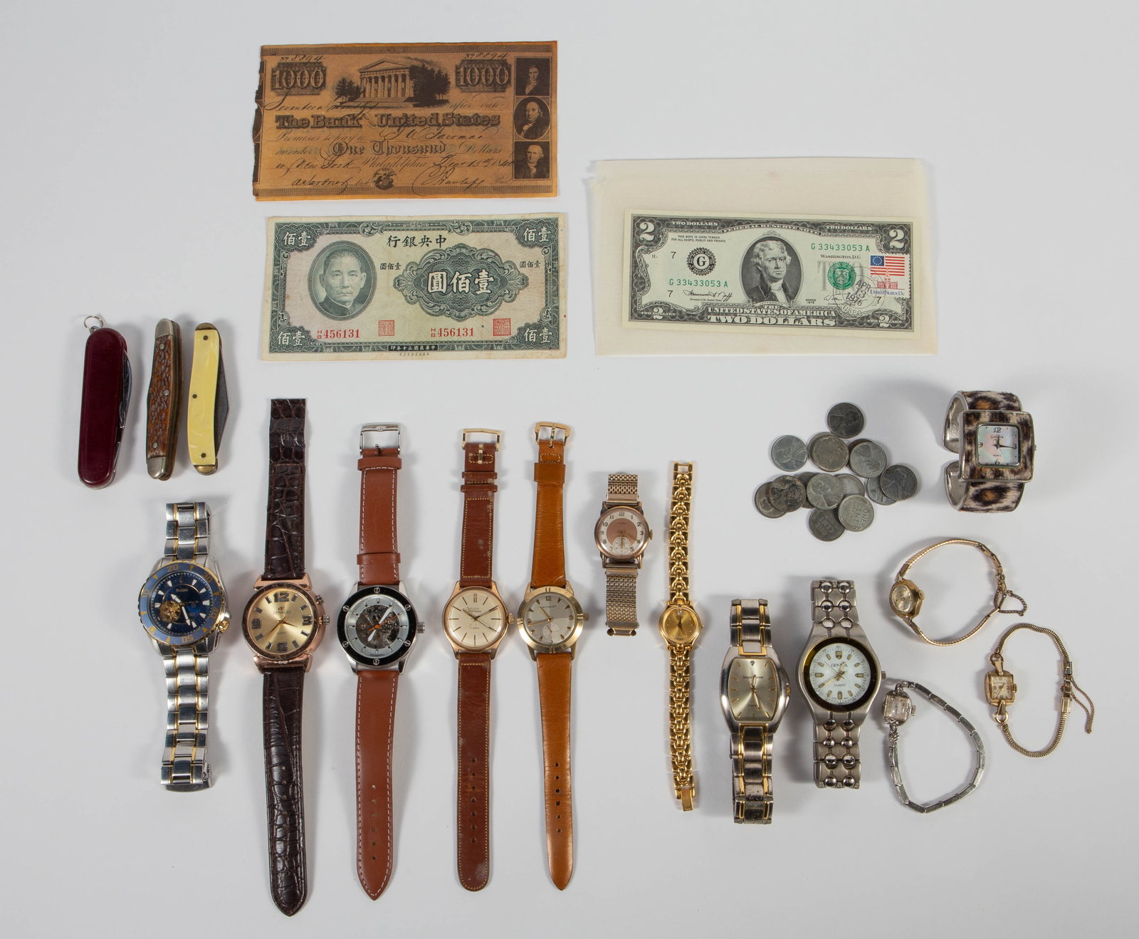 Lot of Vintage Watches, Currency, More - Bulova.: The lot contains 13 wristwatches, 3 pocket knives, and some old currency. There is a Bulova Marine Star 21 jewel chronograph watch with a skeleton back and movement window on the face. The case (large