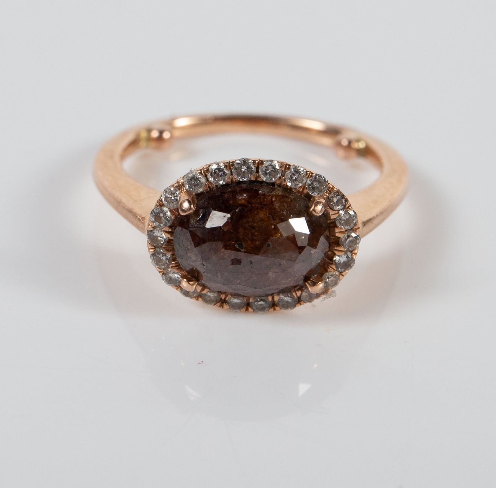 10K Rose Gold Halo Ring w/ Chocolate Diamond.: The ring is unmarked, but tested appropriately for 10K gold. It features a multifaceted oval chocolate diamond surrounded by a halo of small round clear diamonds. The chocolate diamond measures