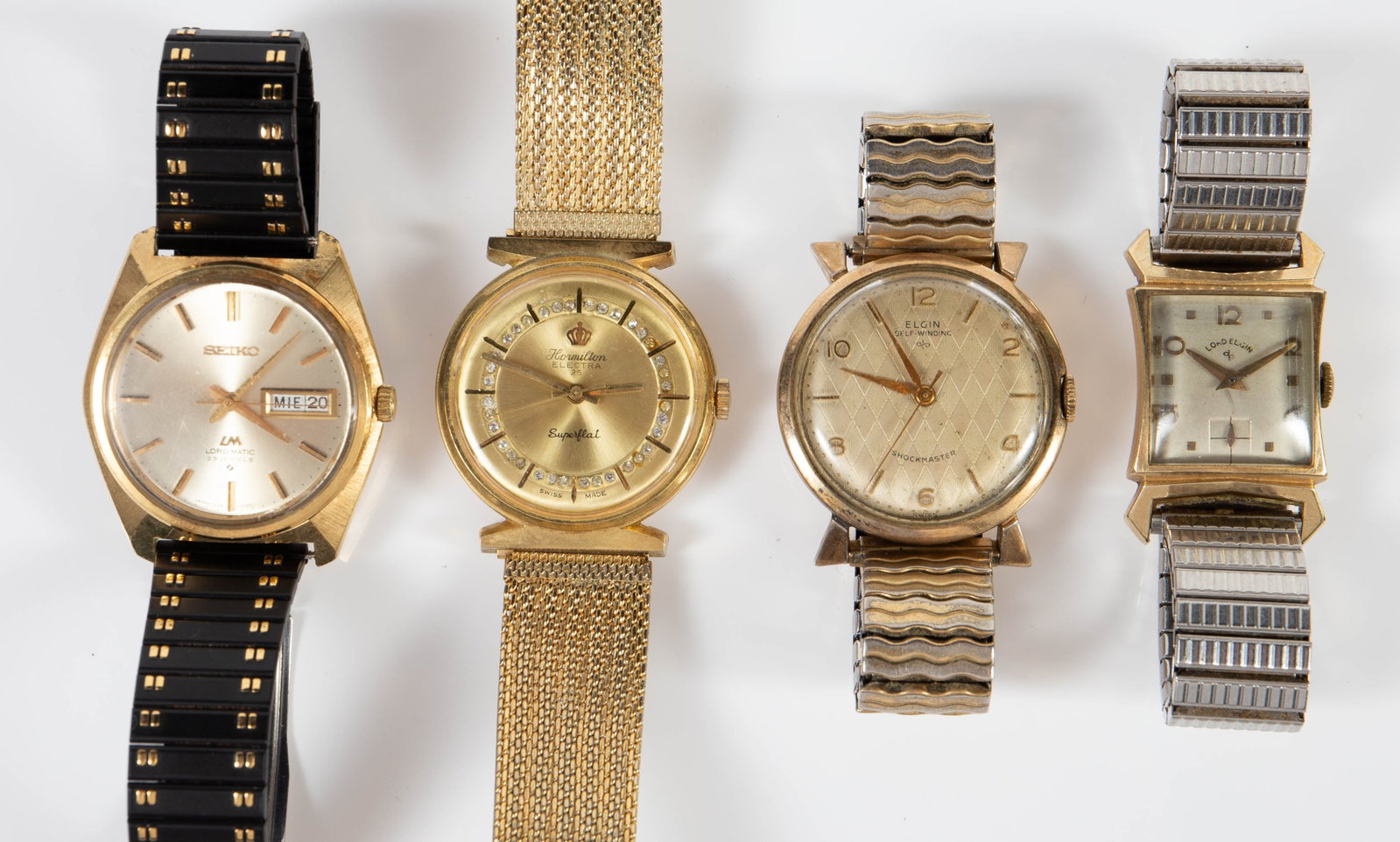 4 Vintage Men's Watches - G.F., Lord Elgin, Seiko.: The lot contains 4 gold tone vintage men's wristwatches. There is a Seiko Lord Matic 23 jewels calendar, a Lord Elgin Art Deco 14K gold filled, an Elgin self-winding, and a Hormilton Electra Superflat