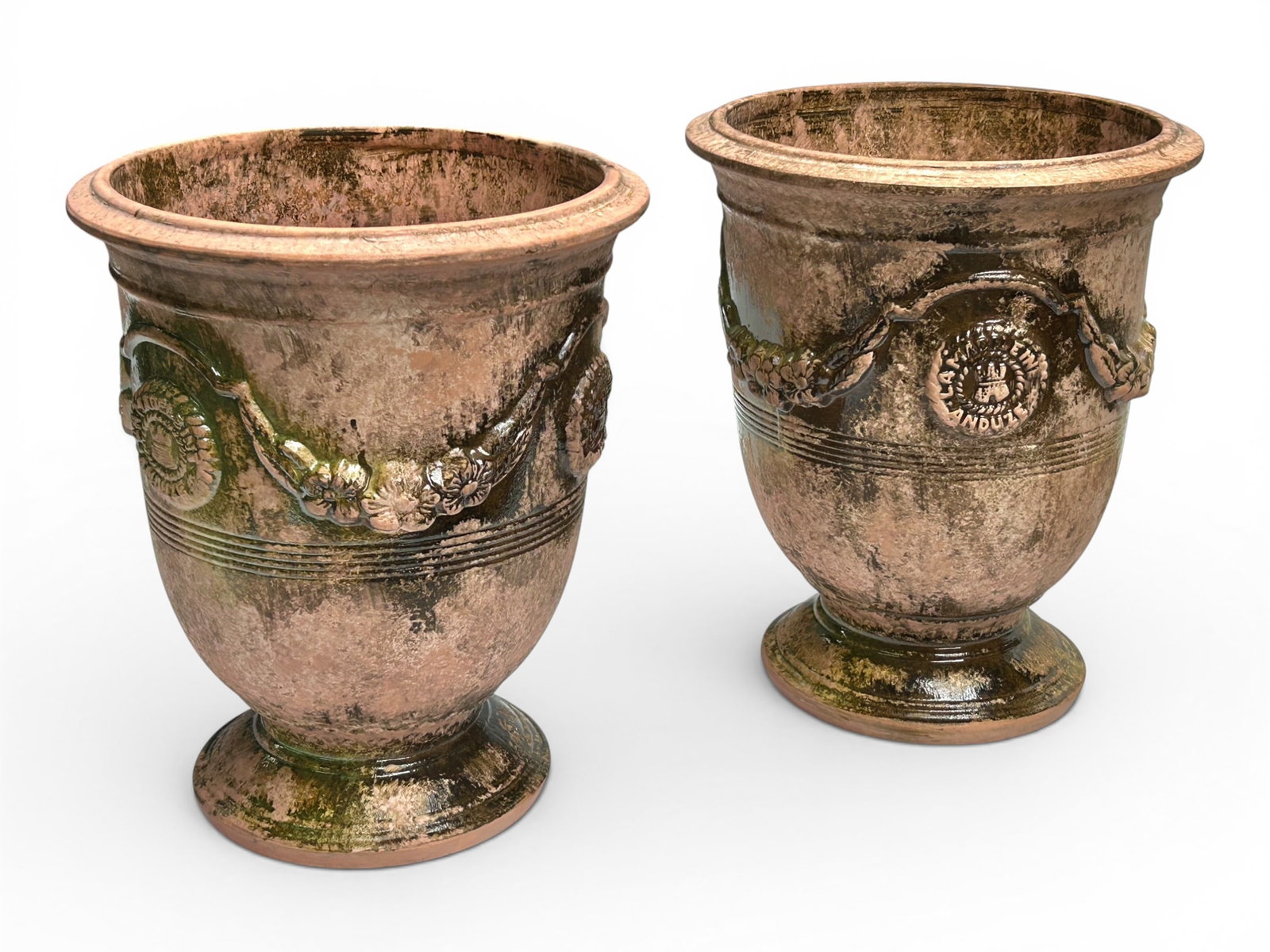 2 Garden Planters Aft. La Madelaine Anduze France.: The pair of vintage likely terracotta garden planters are branded La Madeleine Anduze on three medallion decorations on each planter. They have some green and brown glaze throughout, but most of the p