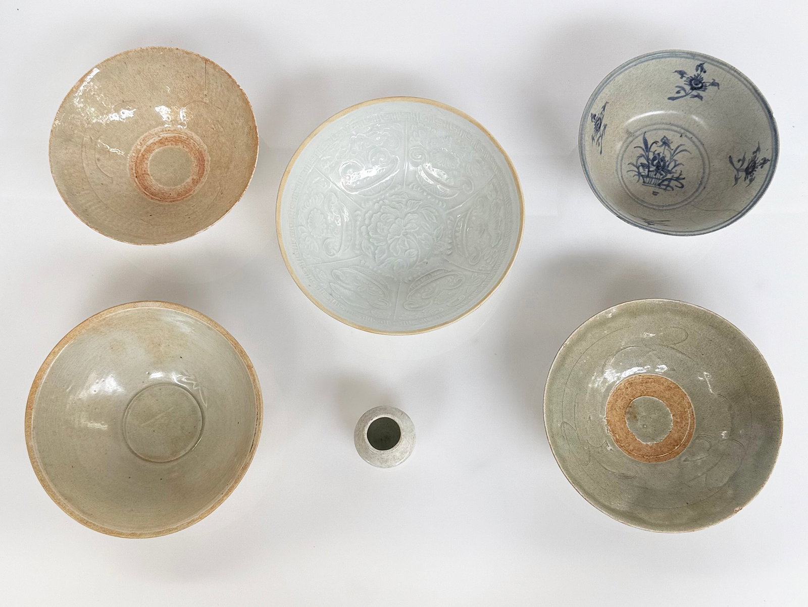 Lot of 15th Century Chinese Porcelain Items.: Some pieces are Yaozhou porcelain, some pieces are celadon, and one is blue and white. Two of the bowls are in good condition - the embossed pattern one and the one with the spatter design on the outs