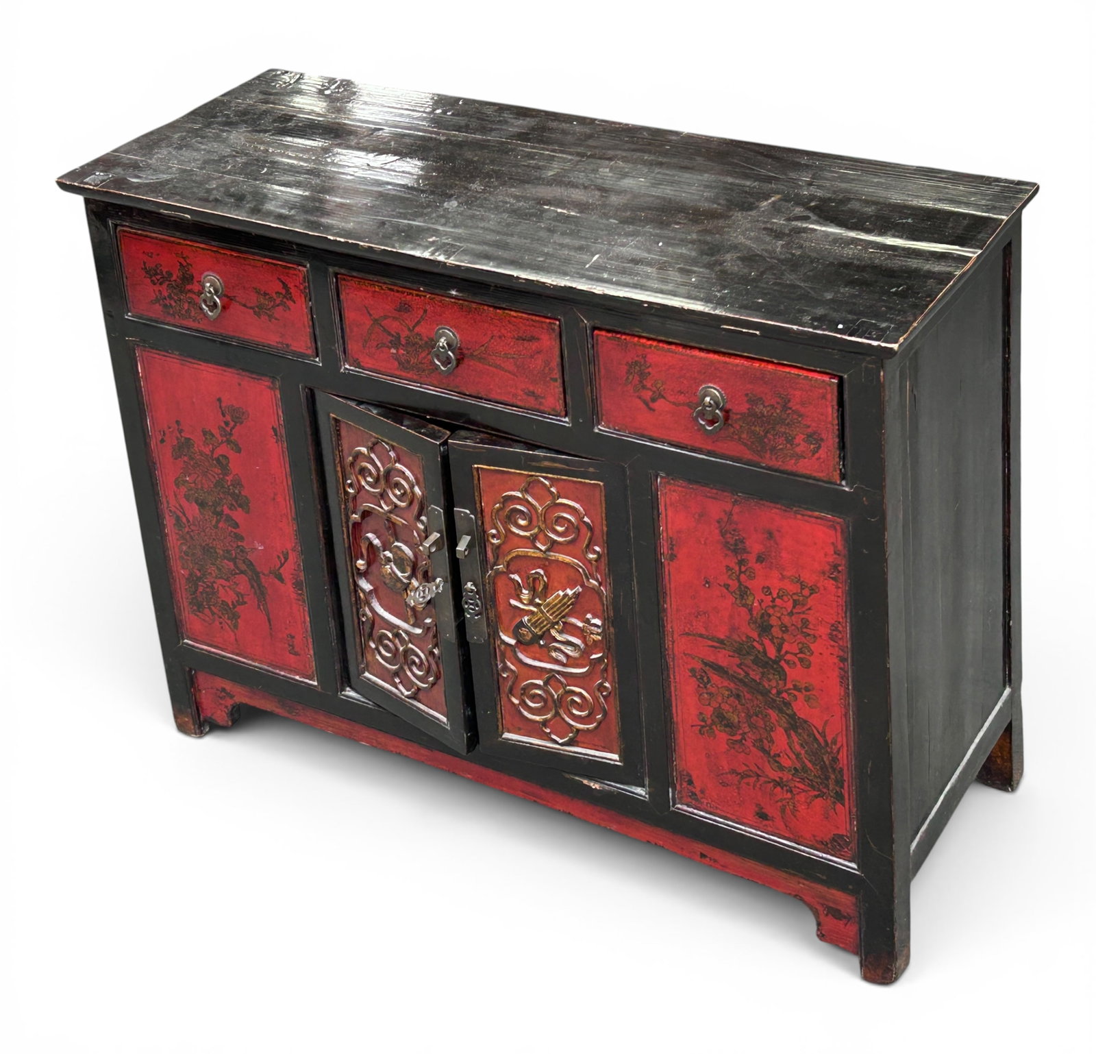 Black and Red Lacquer Asian Cabinet.: The cabinet has three upper drawers, two lower doors, and one interior shelf. It features carvings on the doors and floral details on the drawers. The hardware is brass. There are scratches,