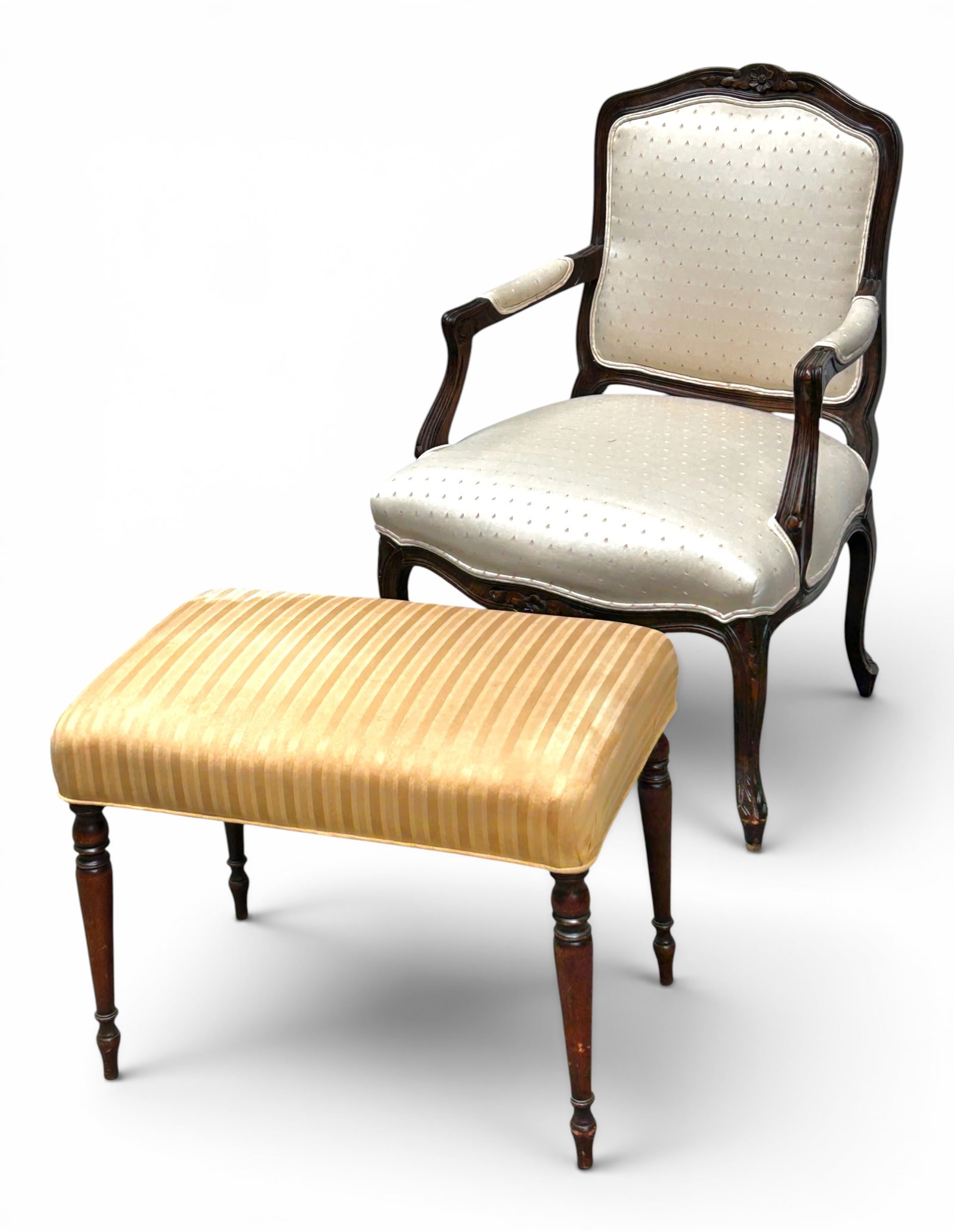 Carved French Armchair & Footstool.: The chair and footstool do not match. The Louis XV armchair has a walnut frame with floral carvings, an upholstered seat/backrest, and carved feet. The footstool has striped fabric and turned dark woo