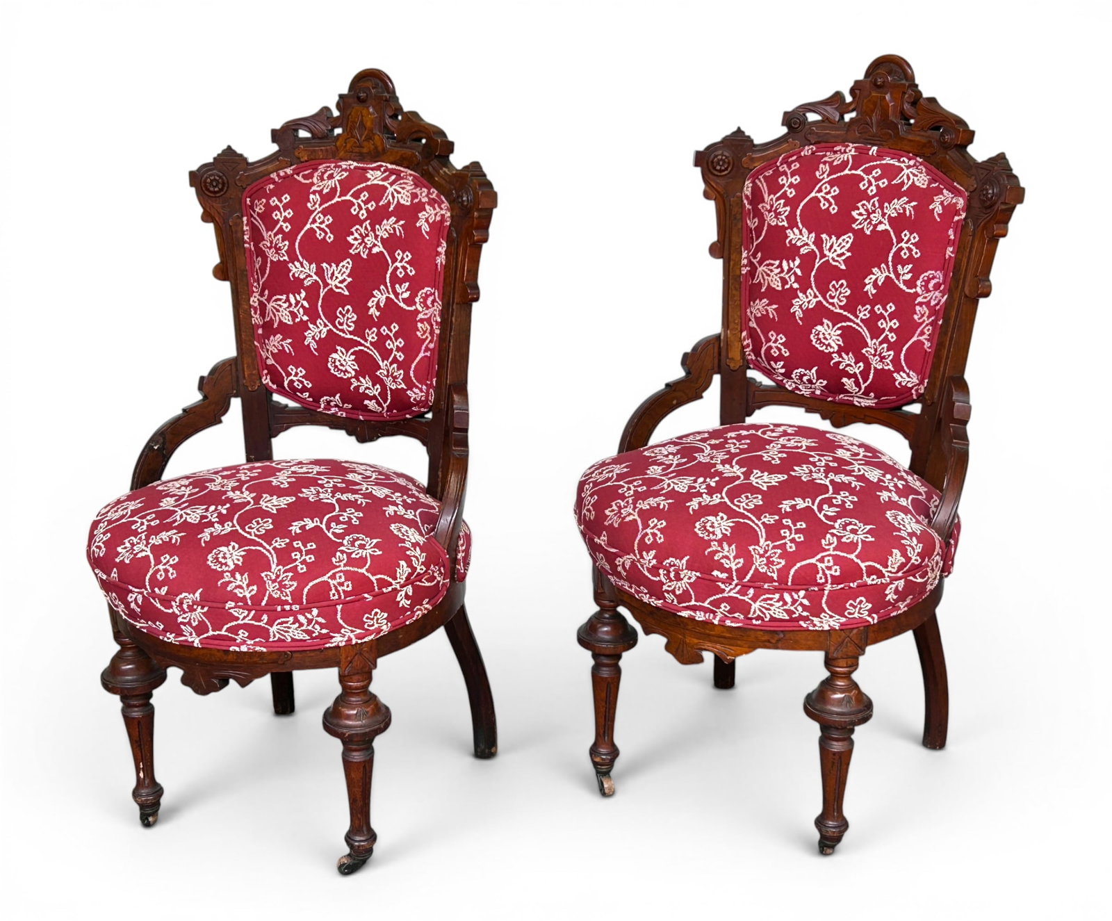 Pair of Antique Victorian Parlor Chairs.: These carved Victorian parlor or side chairs have red floral upholstery. The front legs have wood casters. There are a few chips, indentations, and scratches, but overall, they are in good condition.