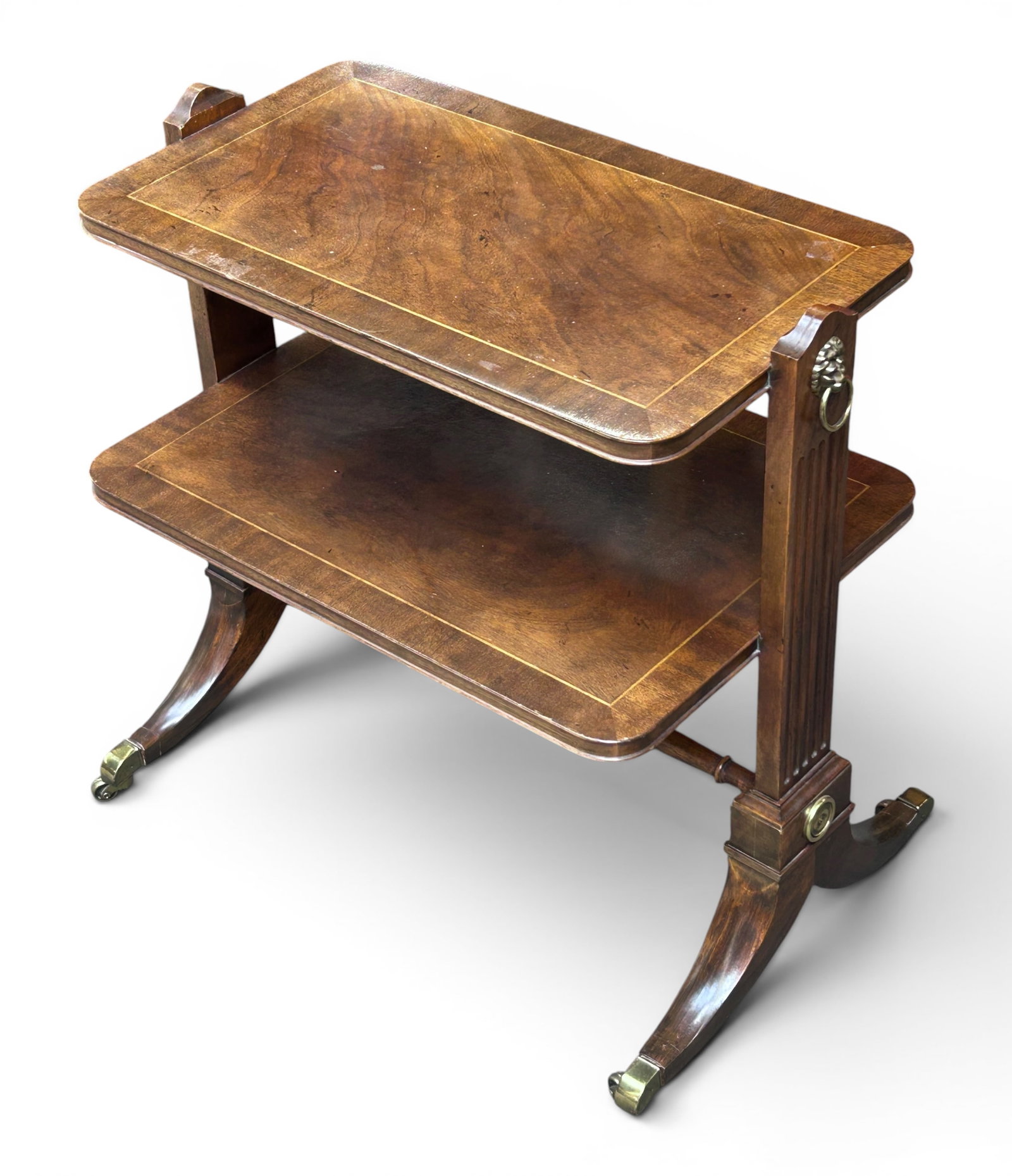 Baker Georgian Mahogany 2-Tier Side Table / Shelf.: The vintage piece of furniture has a banded inlay design, brass lion head handles on the sides, splayed legs, and brass capped feet. It sits on four casters. It measures 26" tall, 26" wide, and 17" de