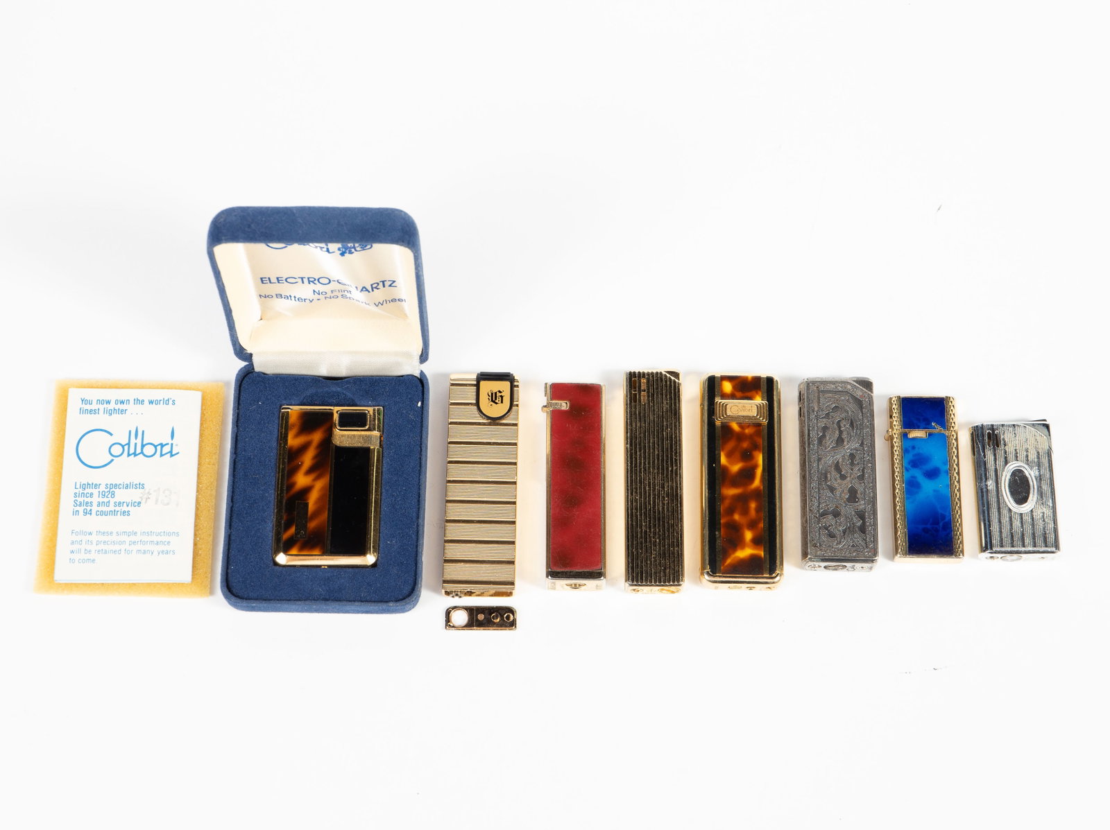 8 Vintage Lighters - Colibri, Ronson, Lucienne.: The lot contains 8 reusable pocket lighters. There are 2 Colibri pieces with tortoise shell designs, one of them in the original box. There are 2 more Colibri lighters, a heavily etched piece, and a g