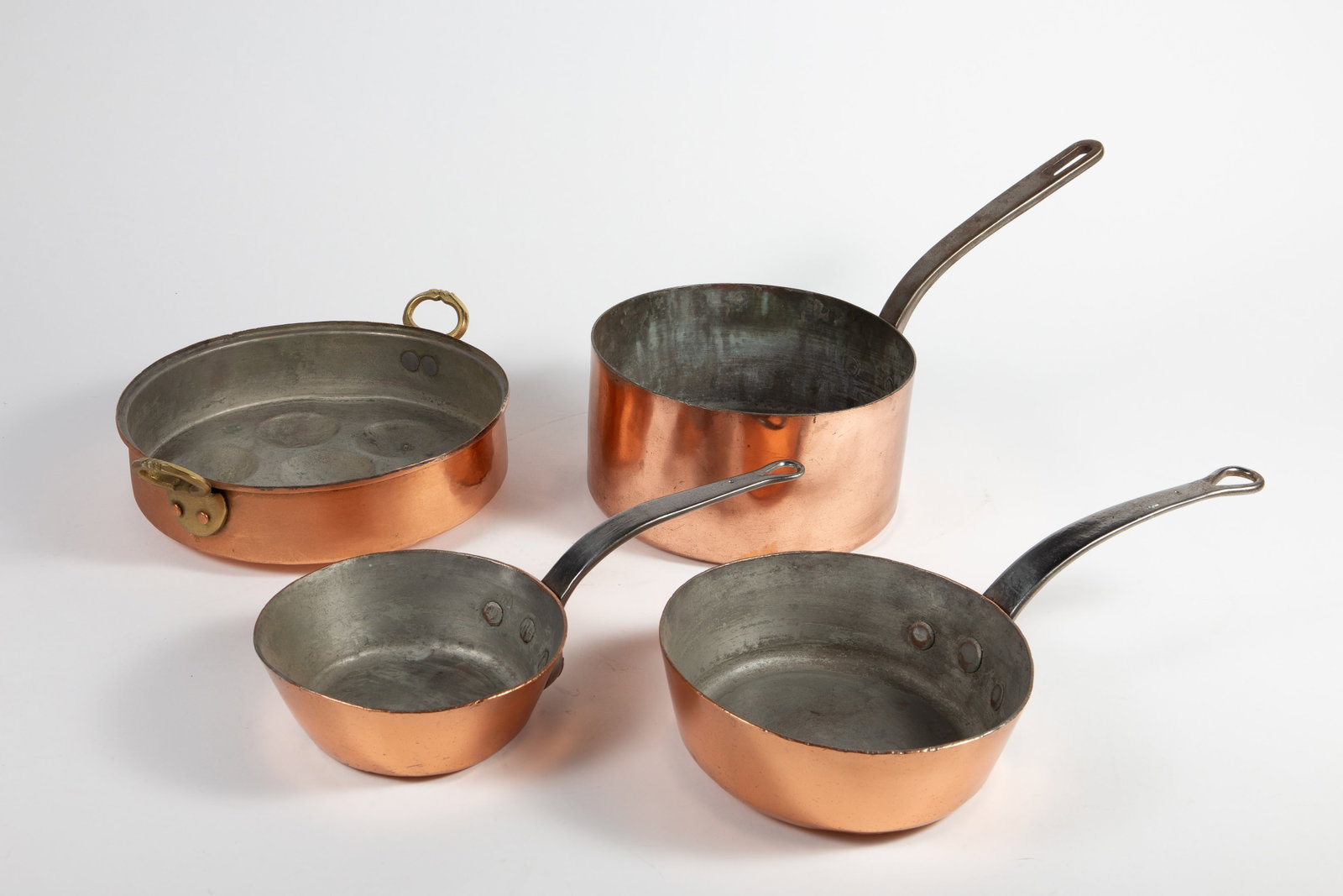 Lot of 4 French Copper Clad Pots & Pans.: One is for poached eggs (has a small hole in the bottom), the other three are long-handled pots. The two smaller ones are stamped, "Paix". There are signs of use and wear, but overall, the lot still