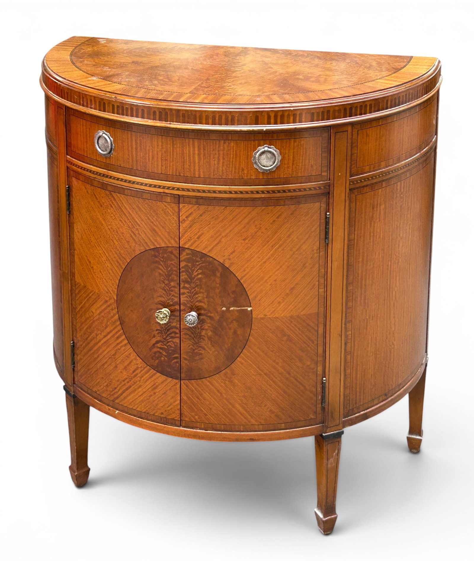 Vintage Satinwood Inlaid Demilune Cabinet: The fine quality cabinet has one drawer with two pulls, and two doors below it with one shelf inside. It has inlaid designs along the edges and borders of the piece, as well as a round design over