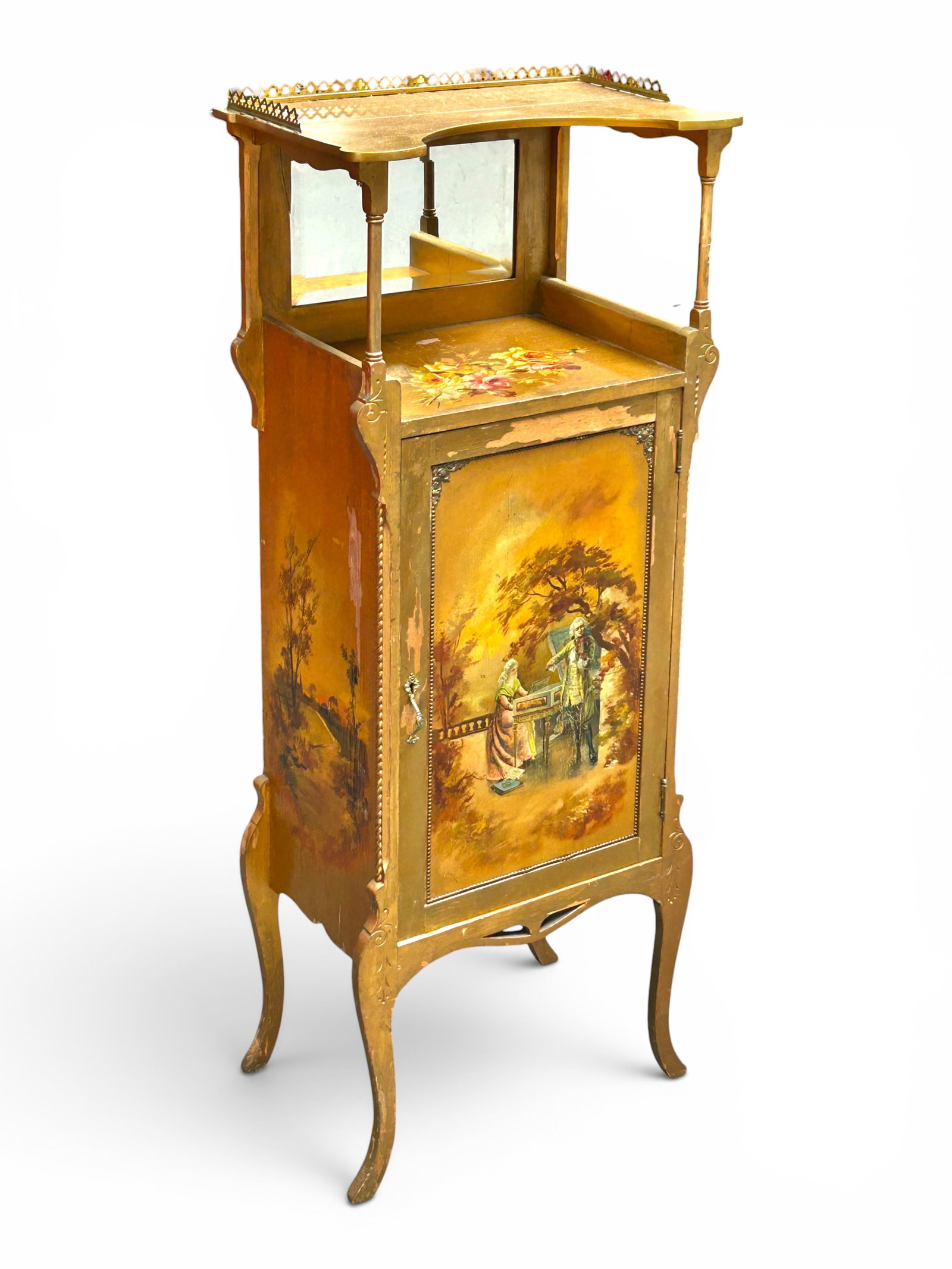 Antique Giltwood Hand Painted Music Cabinet: The piece features hand painted decorations, a pierced brass gallery top and brass relief decorations, turned wood columns, and 6 shelves inside the door. The door features a figural scene of a