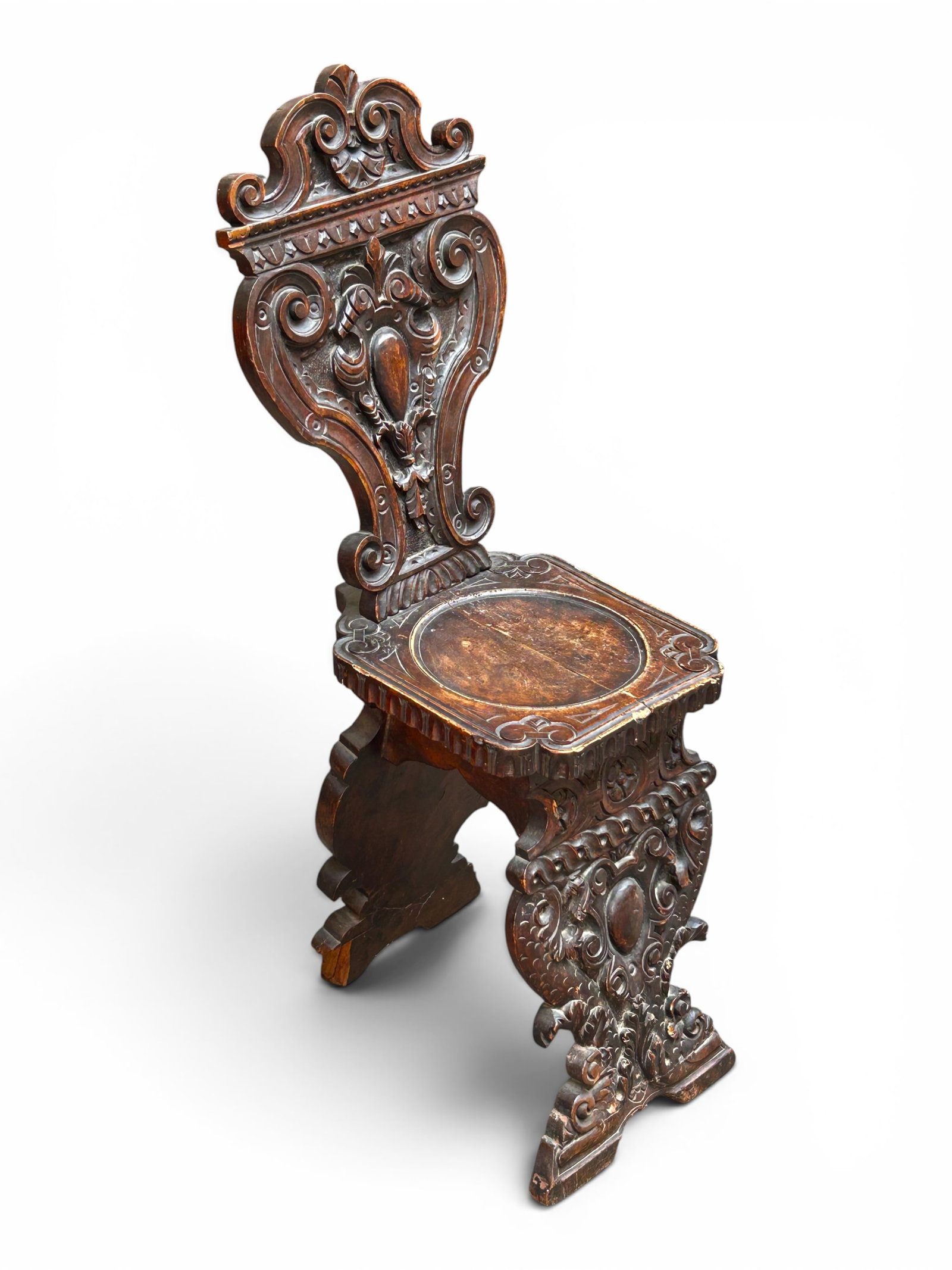 Antique Wormwood Carved Sgabello Chair: The chair boasts scroll and foliage carvings. It measures 42" tall, 12 3/4" wide, and 22" deep. There is a large chip to the left side of the back leg, and there are scratches, stains, chips, cracks, 