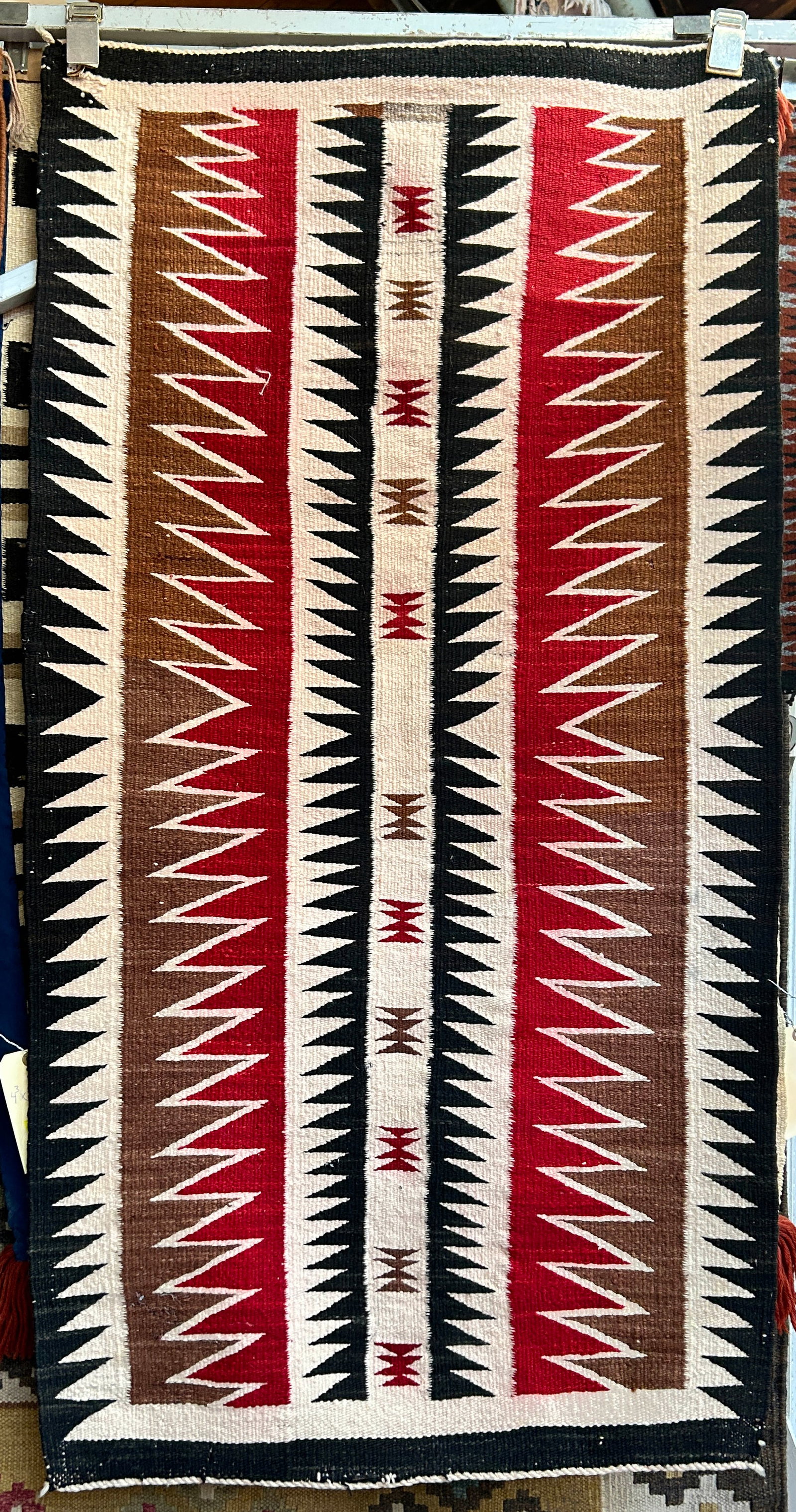 2' 5" x 4' 9" Older Navajo Eye Dazzler Rug.: The rug is coming loose in one area on the end, but is in otherwise good overall condition. In-House Shipping is available for this rug. Please see our website for our in-house shipping procedures.