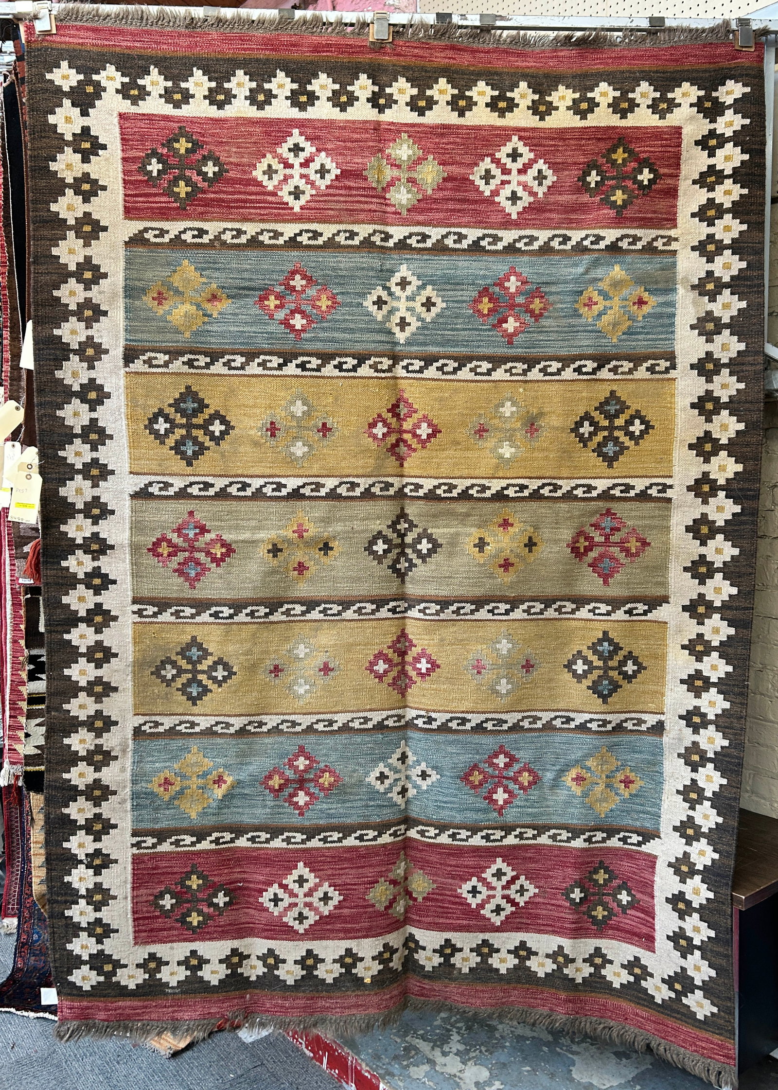 5' 9" x 8' Multicolor Kelim Rug.: The rug looks to be in good overall condition. In-House Shipping is available for this rug. Please see our website for our in-house shipping procedures.
