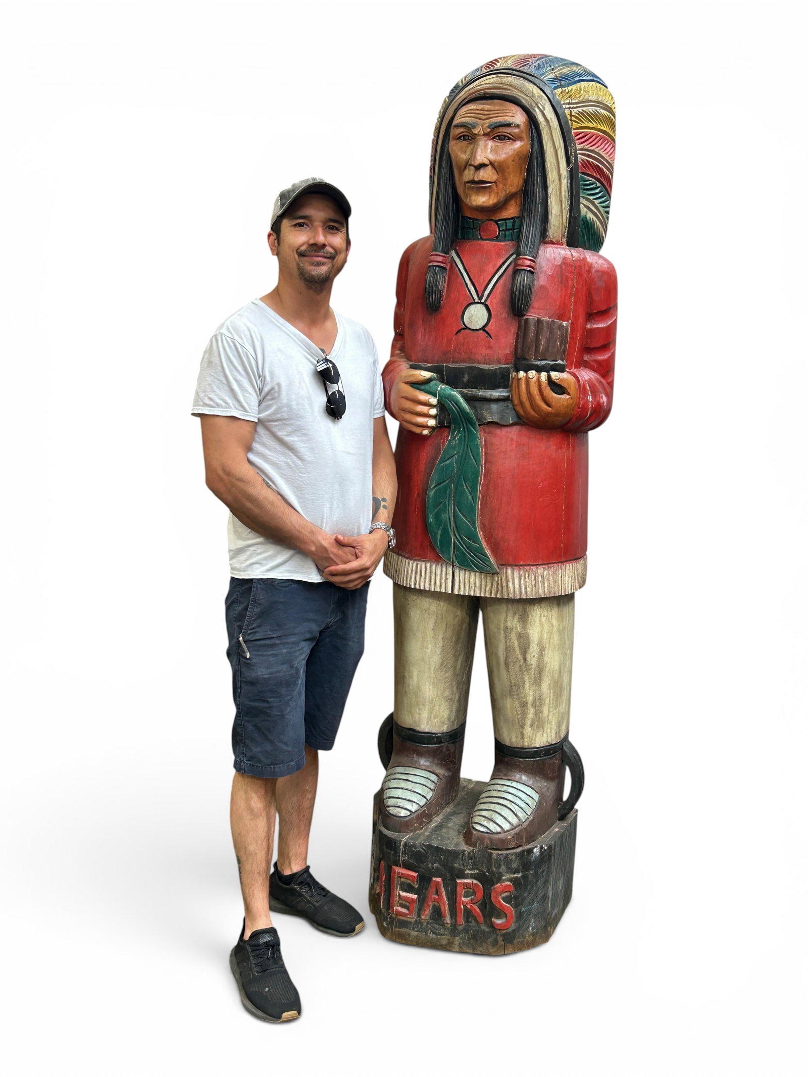 83" Tall Painted Wood Cigar Store Indian Sculpture: The carved wood sculpture depicts an American Indian Chief holding cigars. The piece is labeled Cigars in red on the front of the base. It measures 83" tall, 22" wide, and 19" deep. It has some scratc