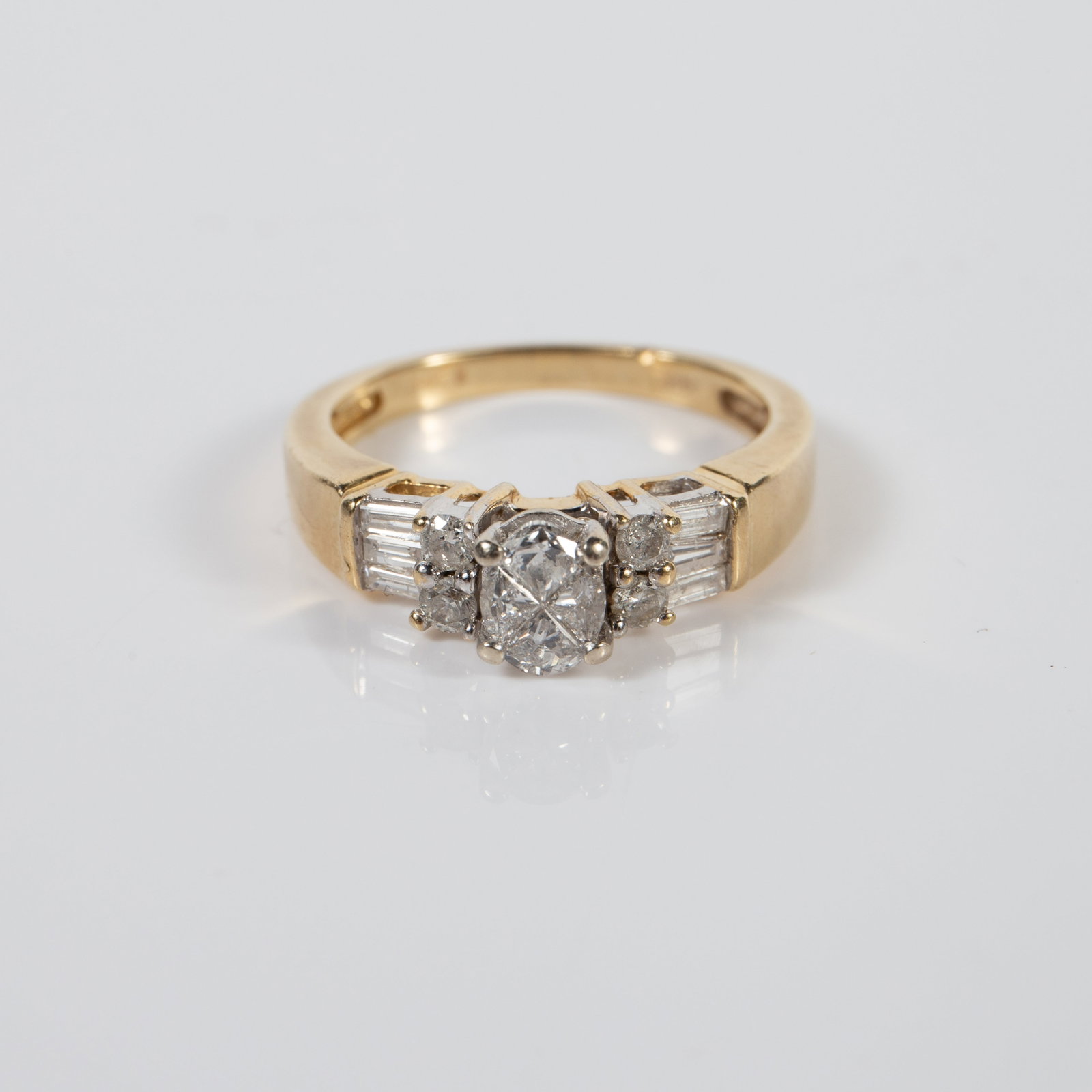 14K Gold and Diamond Engagement Ring.: The ring is marked 14K inside the band. It features a central 4 stone oval cluster, with two round diamonds on each side and 3 baguette cut diamonds on the far ends. It is a size 7, and measures up to